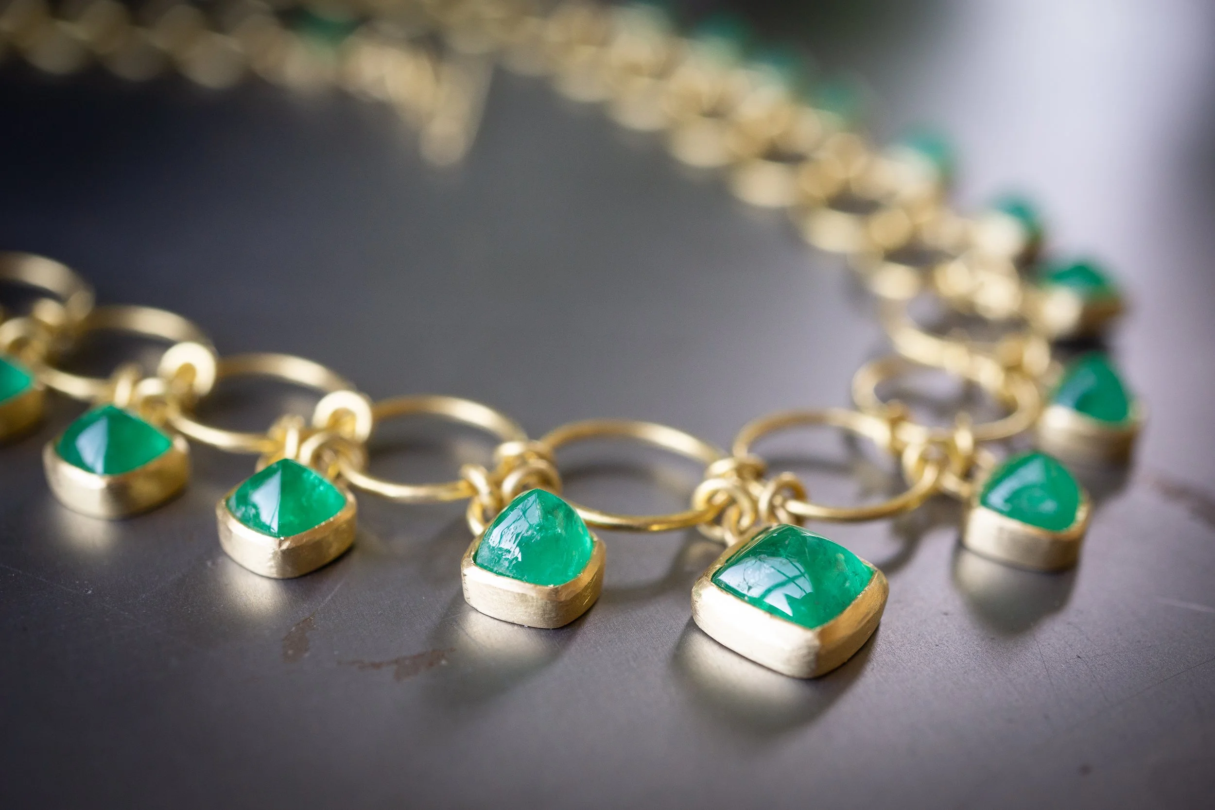 Euclidean Necklace detail showing bezel-set emerald cabochons.