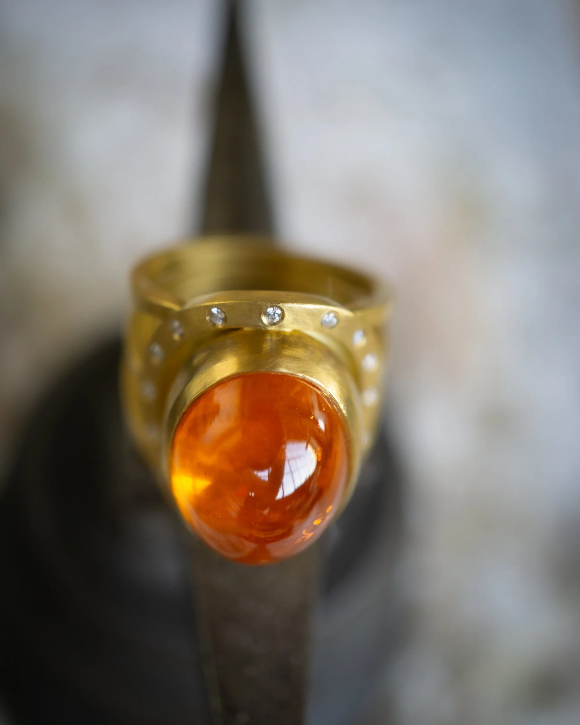 Aurora Ring in 22 karat gold, mandarin garnet, and diamond.