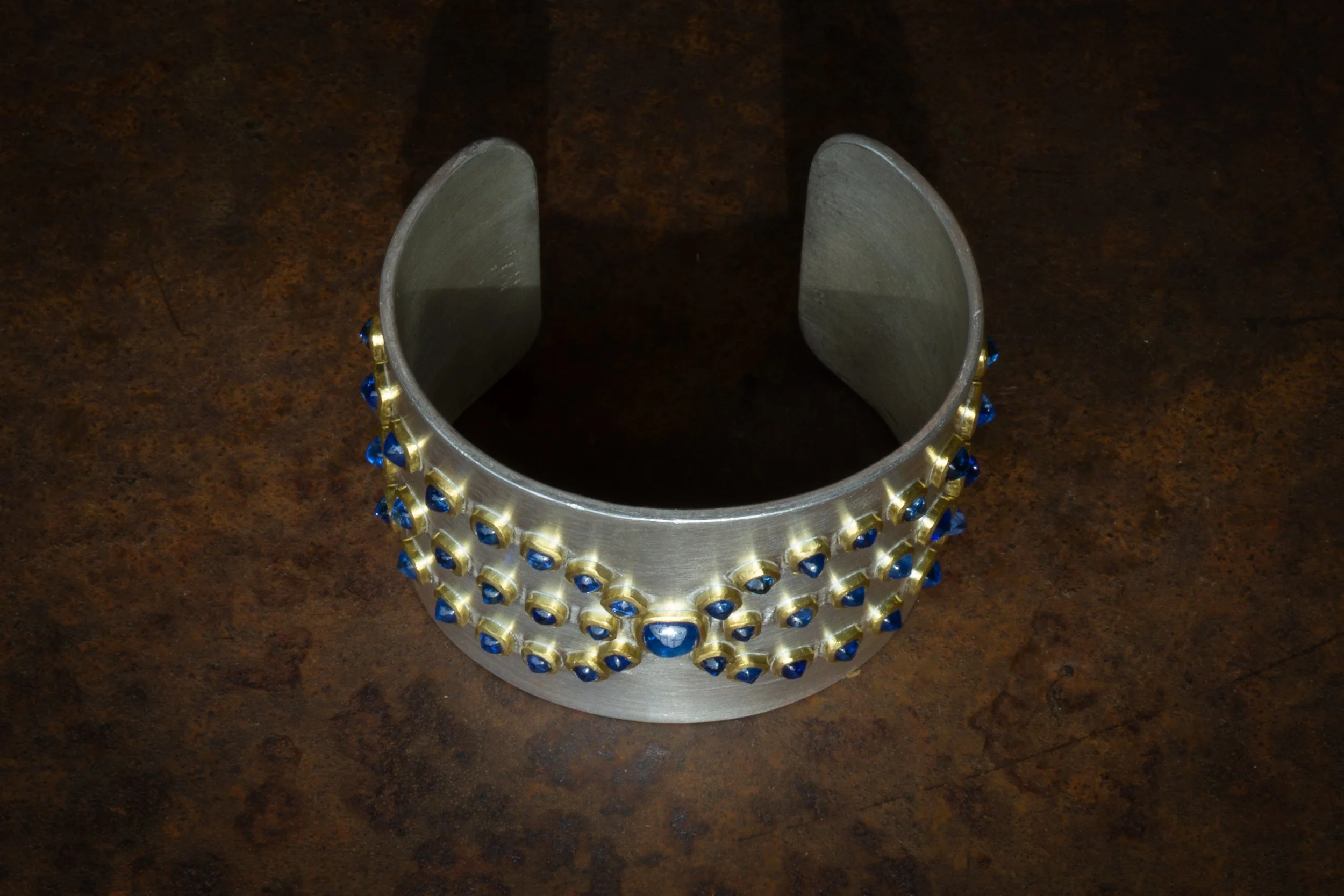 Alcyone Cuff showing elevation of sapphires on the surface.