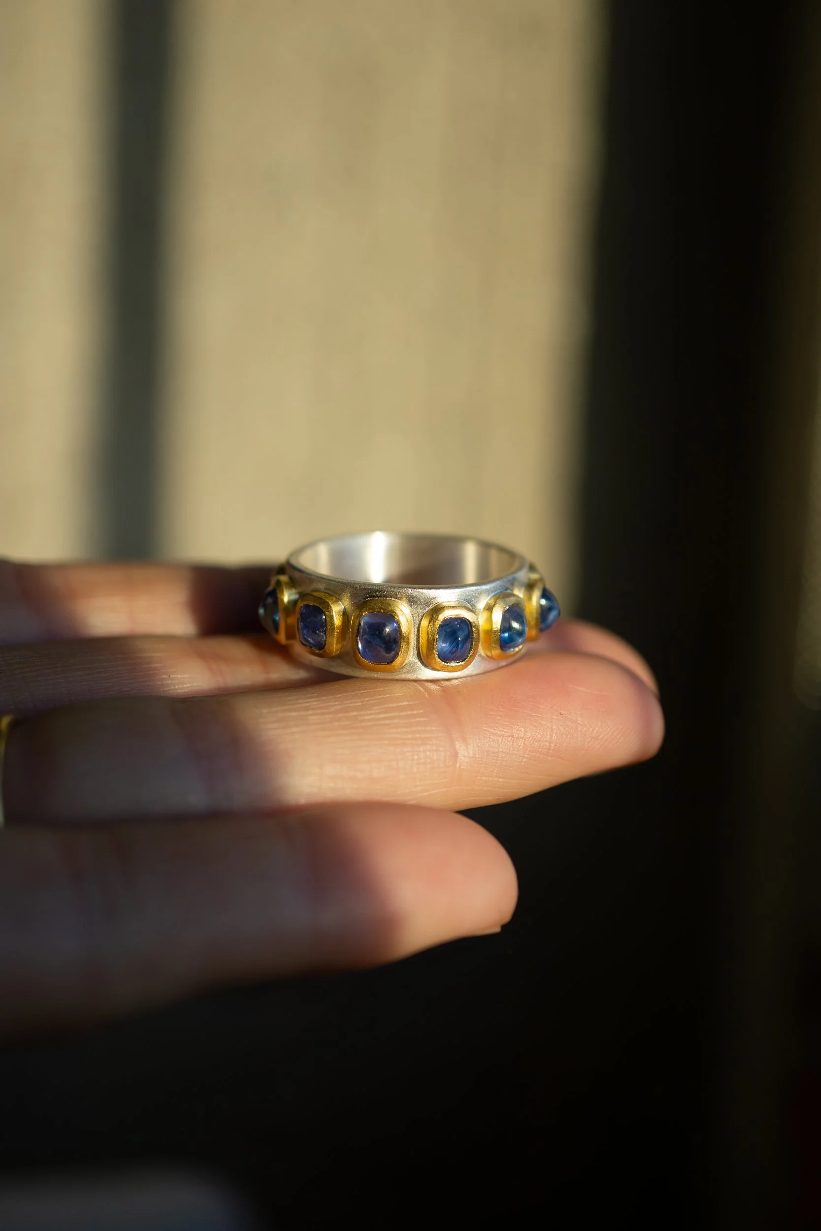 Pleiades Ring held aloft in a sunbeam.