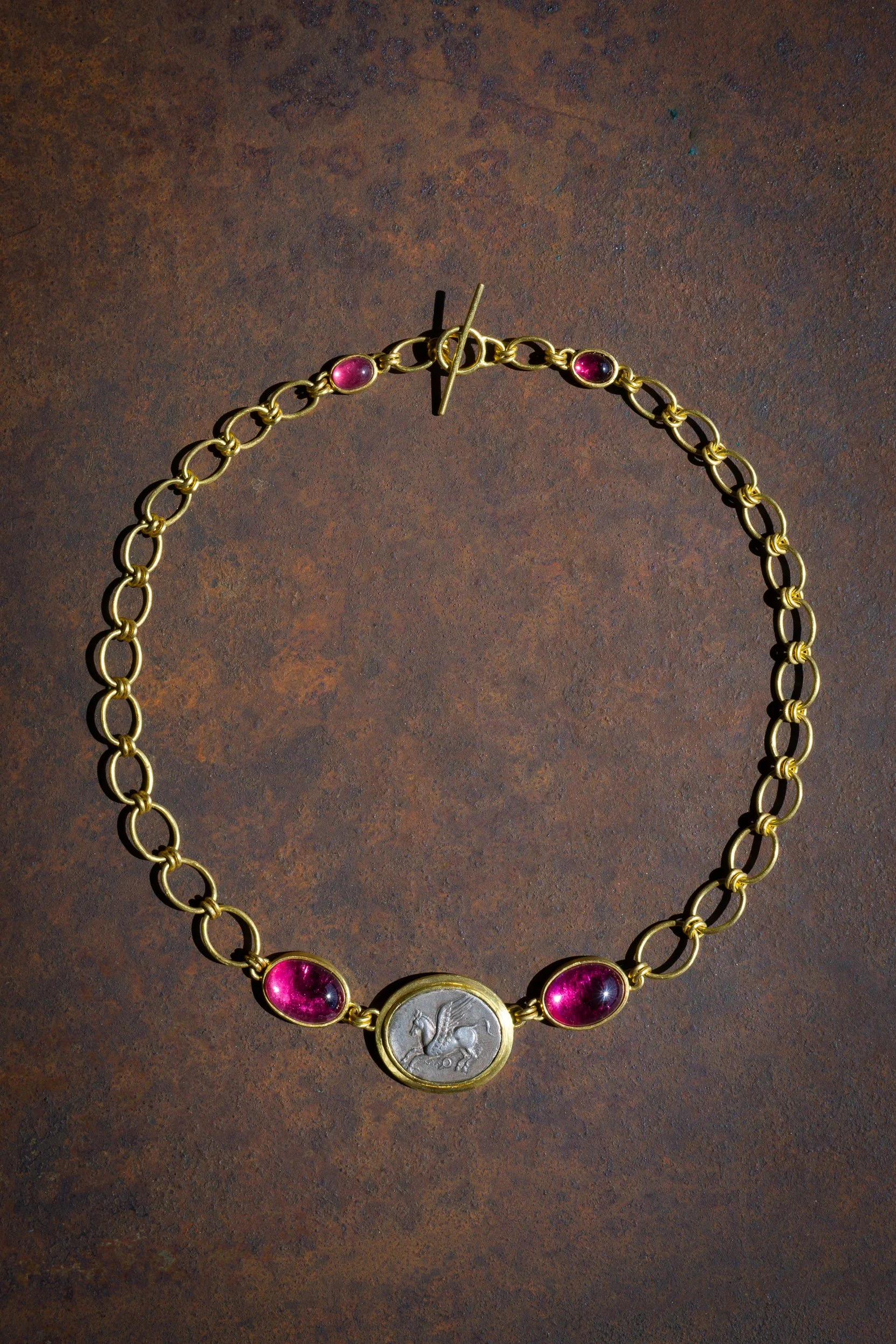 Pegasus Necklace in 22k gold, rubellite cabochons, pink tourmaline cabochons, and ancient coin depicting Pegasus.