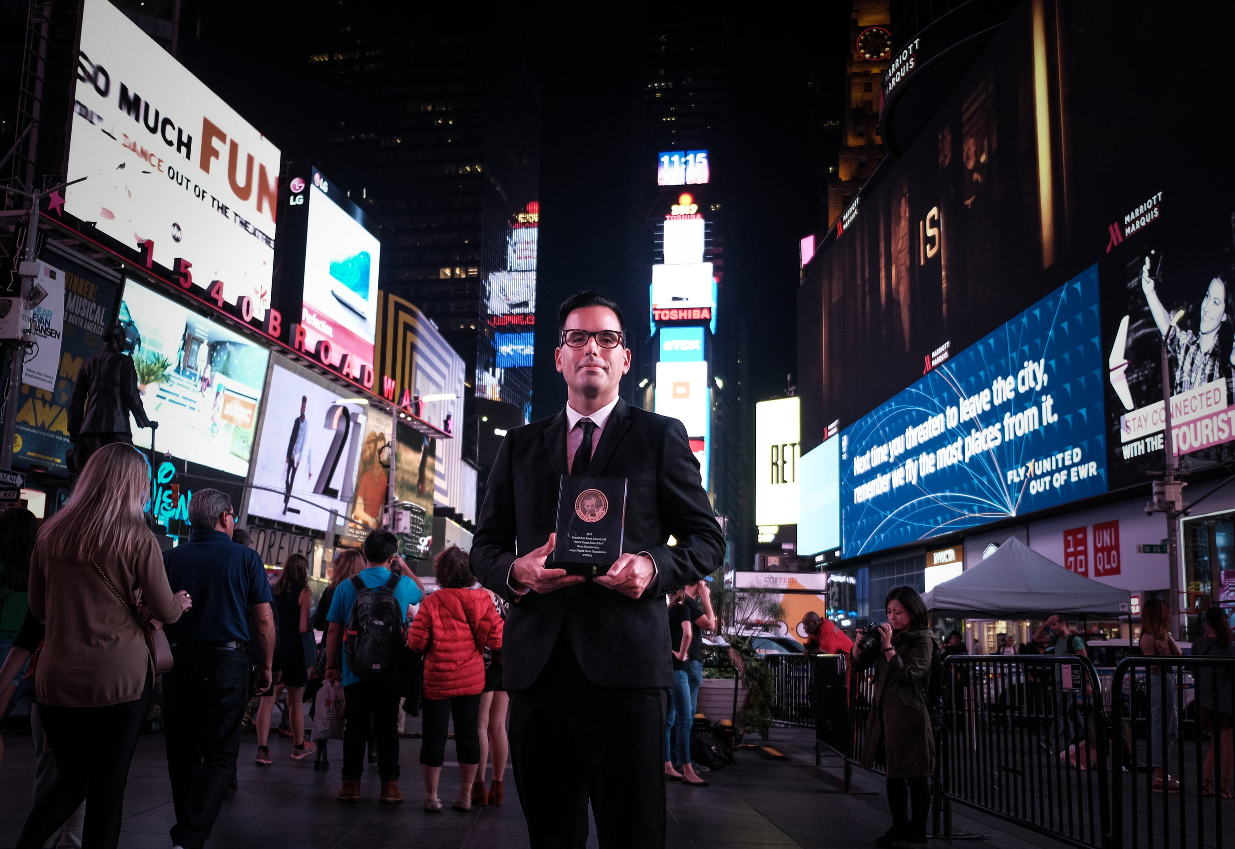  Pop Mod Photo co-owner Ryan Garza poses for a photo in Times Square with his Edward R. Murrow award following the Edward R. Murrow Awards Gala in New York City. Garza's work on the Flint Water Crisis for the Detroit Free Press with co-worker Brian K