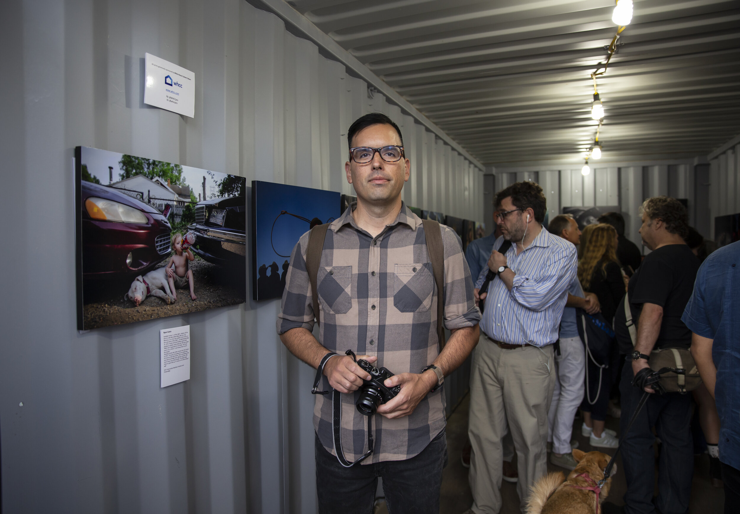  Pop Mod Photo co-owner Ryan Garza stands next to his documentary photo from coverage of the Flint Water Crisis on display as part of the National Press Photographers organizations first gallery at Photoville in Brooklyn, New York. 