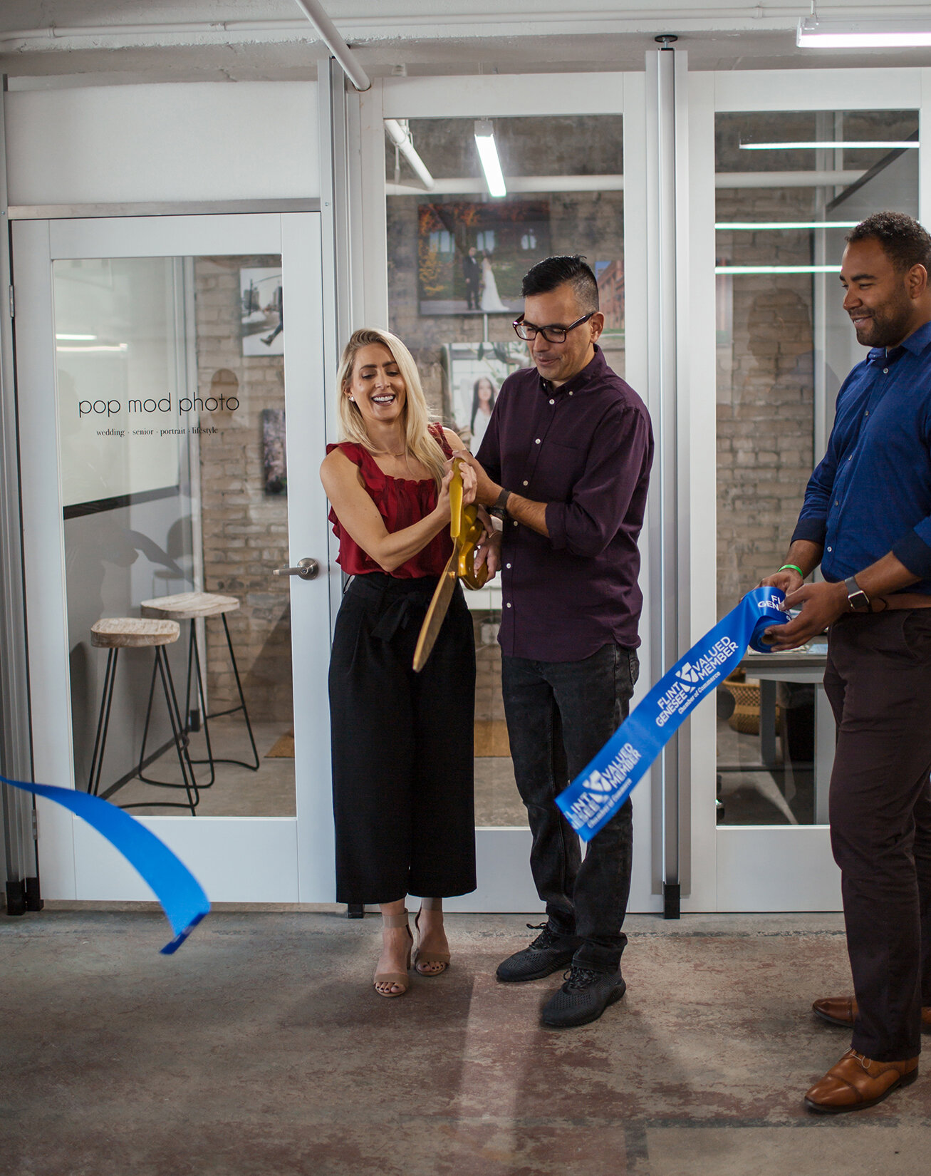  Pop Mod Photo owners Courtney Simpson and Ryan Garza cut the ribbon for the grand opening of their photo studio at the Ferris Wheel building in downtown Flint along with the Genesee Area Chamber of Commerce. 