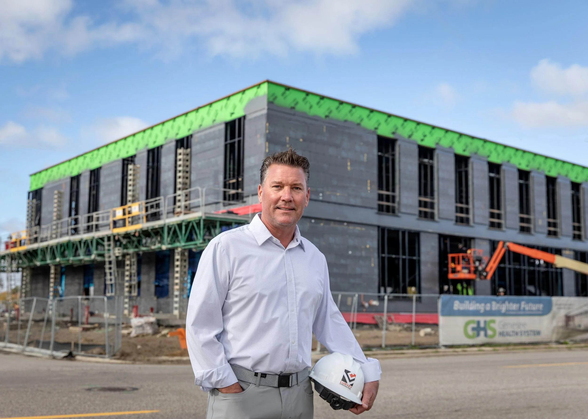  On location business headshot photo session of Dave Lurvey of DW Lurvey Construction outside of the Genesee Health System building in downtown Flint, Michigan by Pop Mod Photo photographers Courtney Simpson and Ryan Garza. 