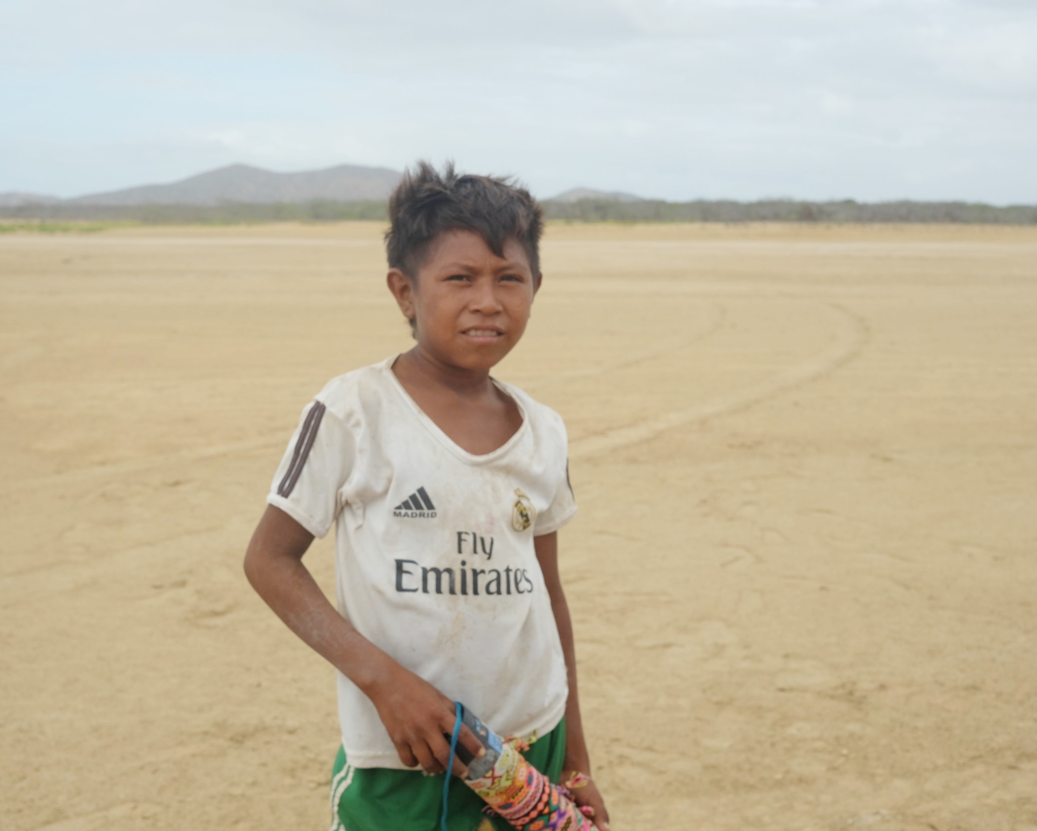 Scrappy kid hustling to sell bracelets.