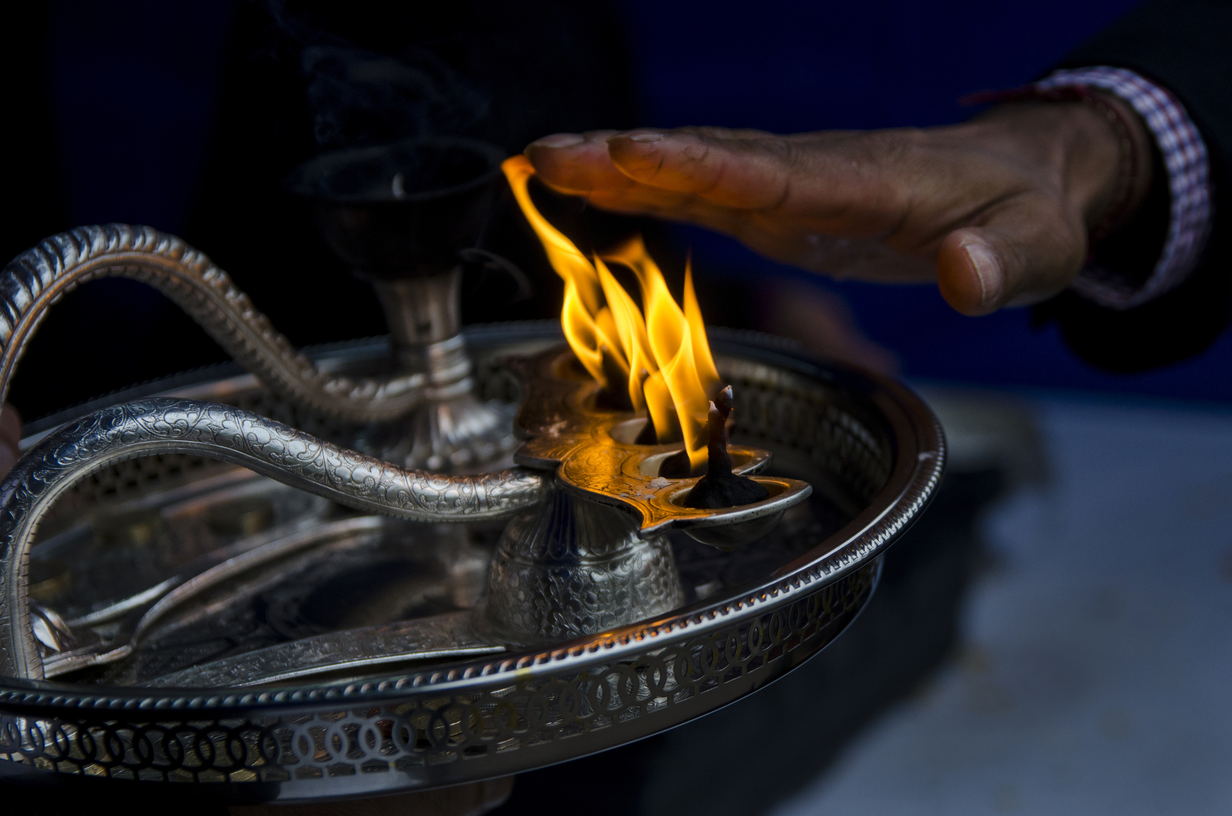 As community members exit the temple at Bhaktivedanta Manor after praying to the gods, they lay their hands close to this flame and say a prayer at the annual Diwali festival.