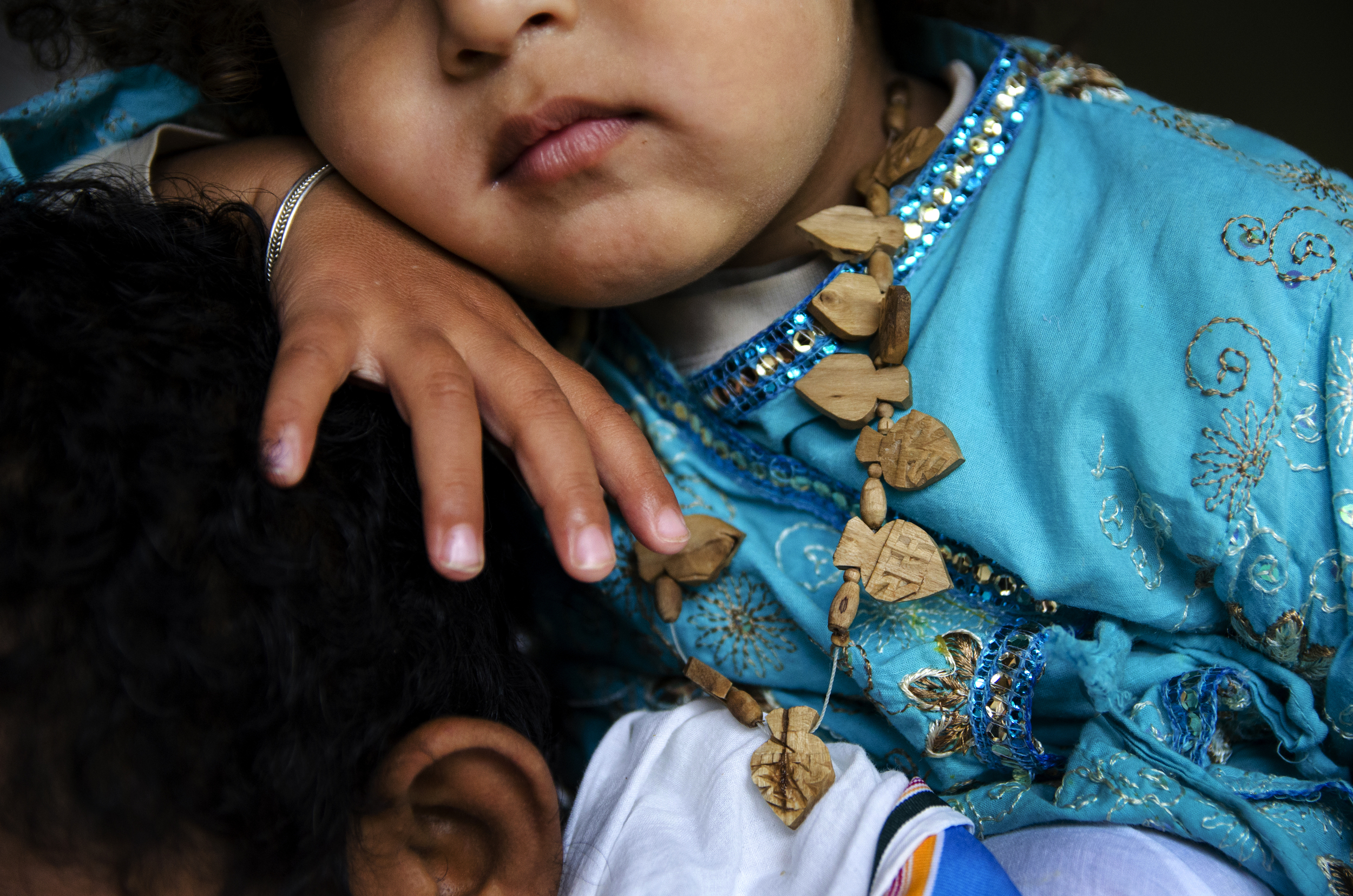 A young boy sits on his father's shoulders as he chats with fellow community members wishing them a "Happy Diwali" at the Bhaktivedanta Manor Diwali celebration. 