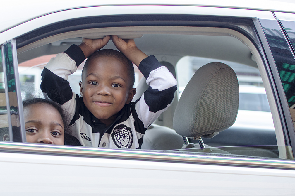  Two children wait in the car as their parents go grocery shopping at an outdoor fresh food shop in downtown Pittsburgh, PA. 