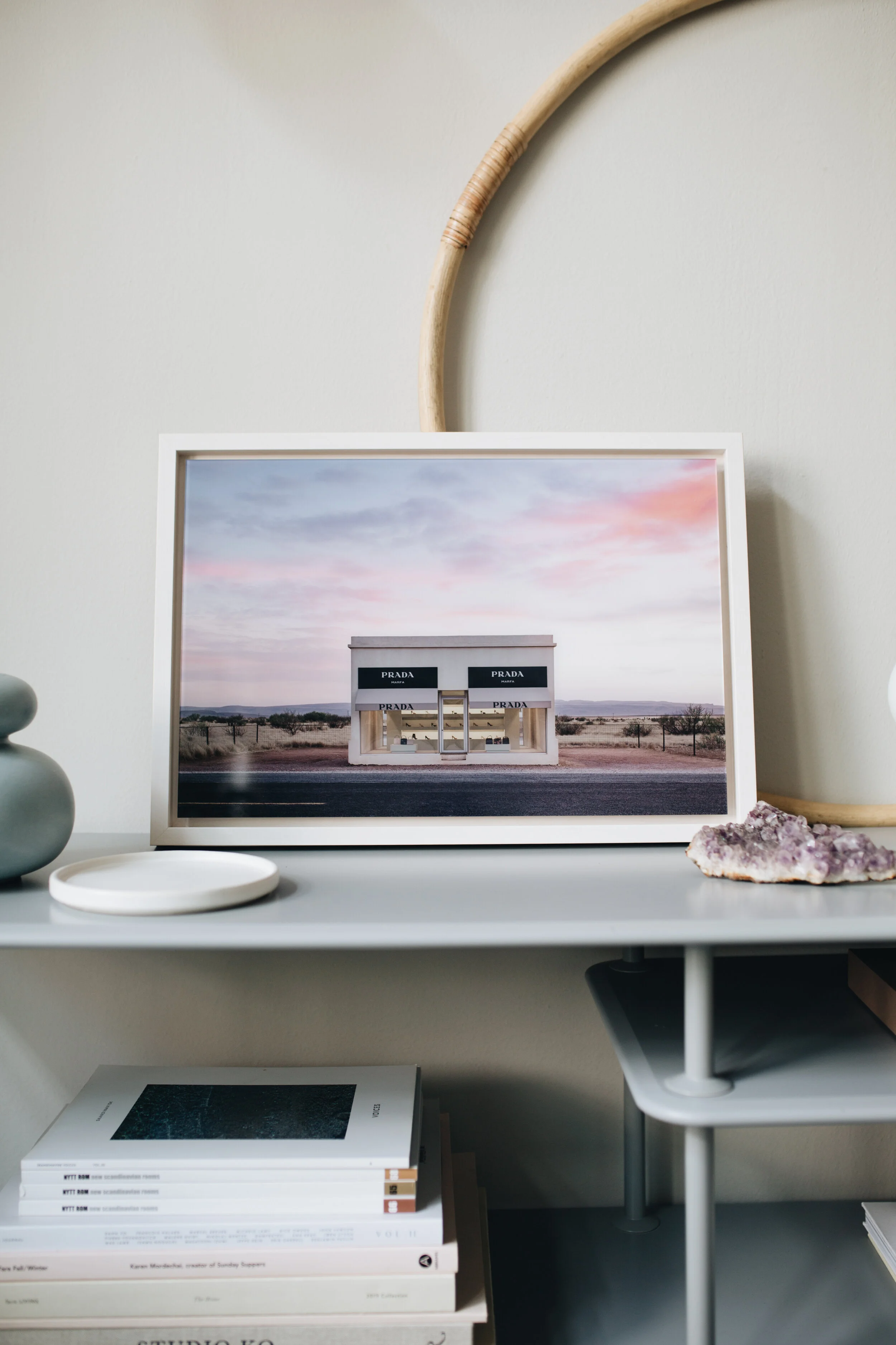Prada Marfa 8:36PM © Adam Mørk, LUMAS.com   Link zum Werk:  https://www.lumas.de/pictures/adam_moerk/prada_marfa_836pm/   Adam Mørk hat Prada Marfa zu verschiedenen Uhrzeiten fotografiert. „Prada Marfa 8:36PM“ ist Teil dieser Serie.  Der dänische Architekturfotograf Adam Mørk besuchte Marfa, um zwei seiner Idole zu erleben: Donald Judd und Dan Flavin. Tief in der Wüste entdeckte er dann eine brillante Installation: „Der ‚Prada Store‘ wirkt wie ein Katalysator. Menschen aus aller Welt treffen sich hier, unterhalten sich, tanzen und posieren. Sie genießen für mehrere Stunden die Umgebung, das fantastische Licht und die Gesellschaft der anderen“, erzählt er. Mørk fotografierte die Installation von der frühmorgendlichen blauen Stunde bis in den späten Abend. Dabei benannte er jede Aufnahme nach der exakten Uhrzeit, zu der sie geschossen wurde. Auf diese Weise hielt er diese schönen, flüchtigen Momente in der Wüste für alle Ewigkeit fest.