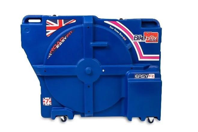 a blue bike travel case side view showing four wheels on the bottom, several side bulges where handlebars and wheels might go, and a handle on the top