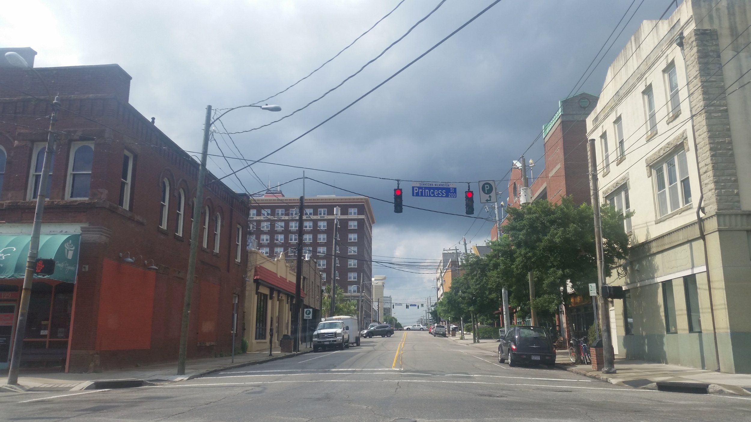 I love the lines of the road, buildings, lights, and powerlines on this random side street. The dark clouds in the background help too.