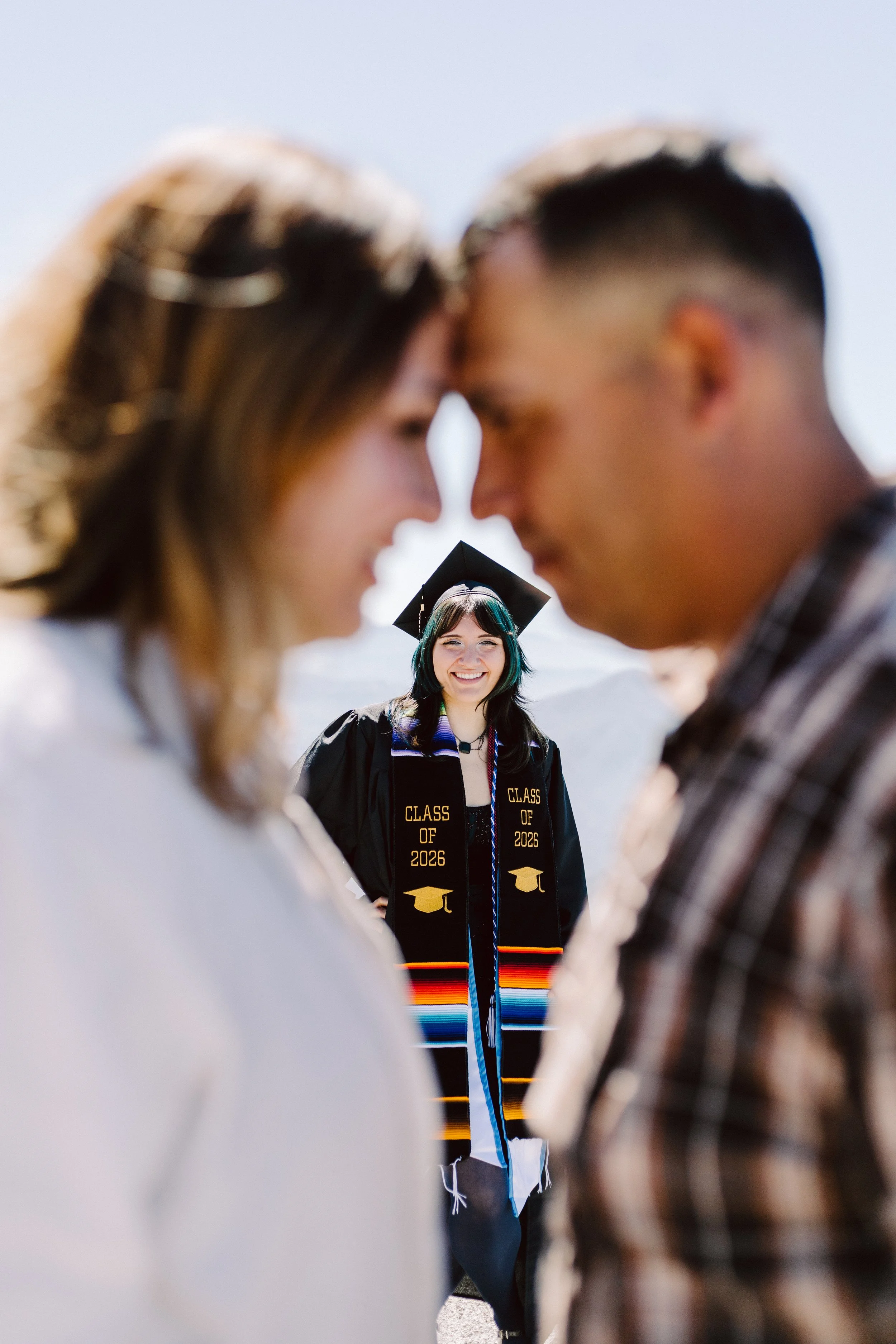 Family celebrating CSUSB graduation together outdoors