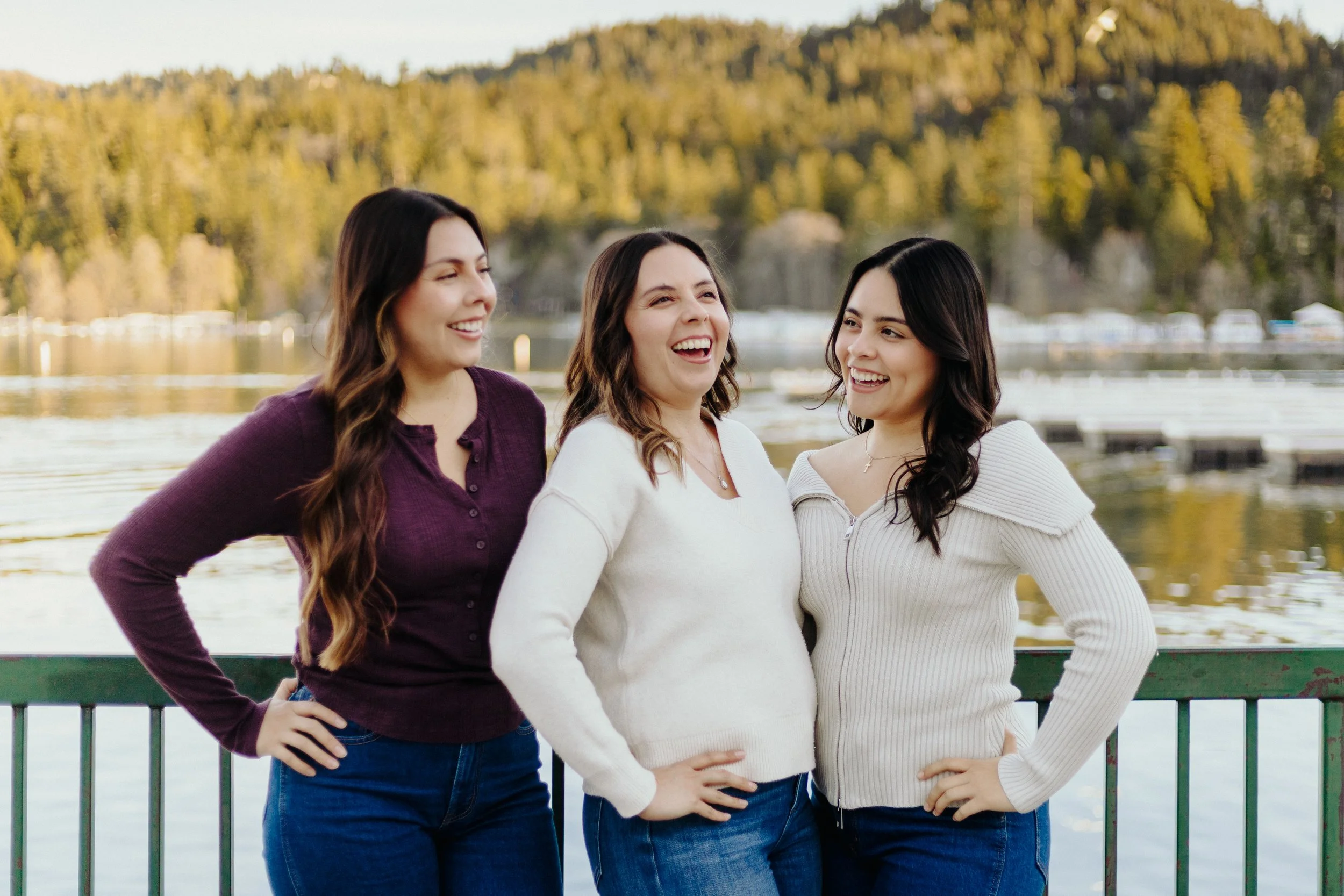 Mother and daughters standing by a mountain lake celebrating a birthday together with scenic mountain views behind them.