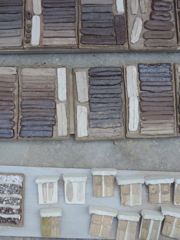 Various tests made by participants during the workshop. Upper tiles: line blend tests of two low-firing clays with refractory Bennington kaolin. Lower left: aggregate tests of crushed stones. lower right: vitreous slip tests made from commercial clay with additions of silty clay soil.
