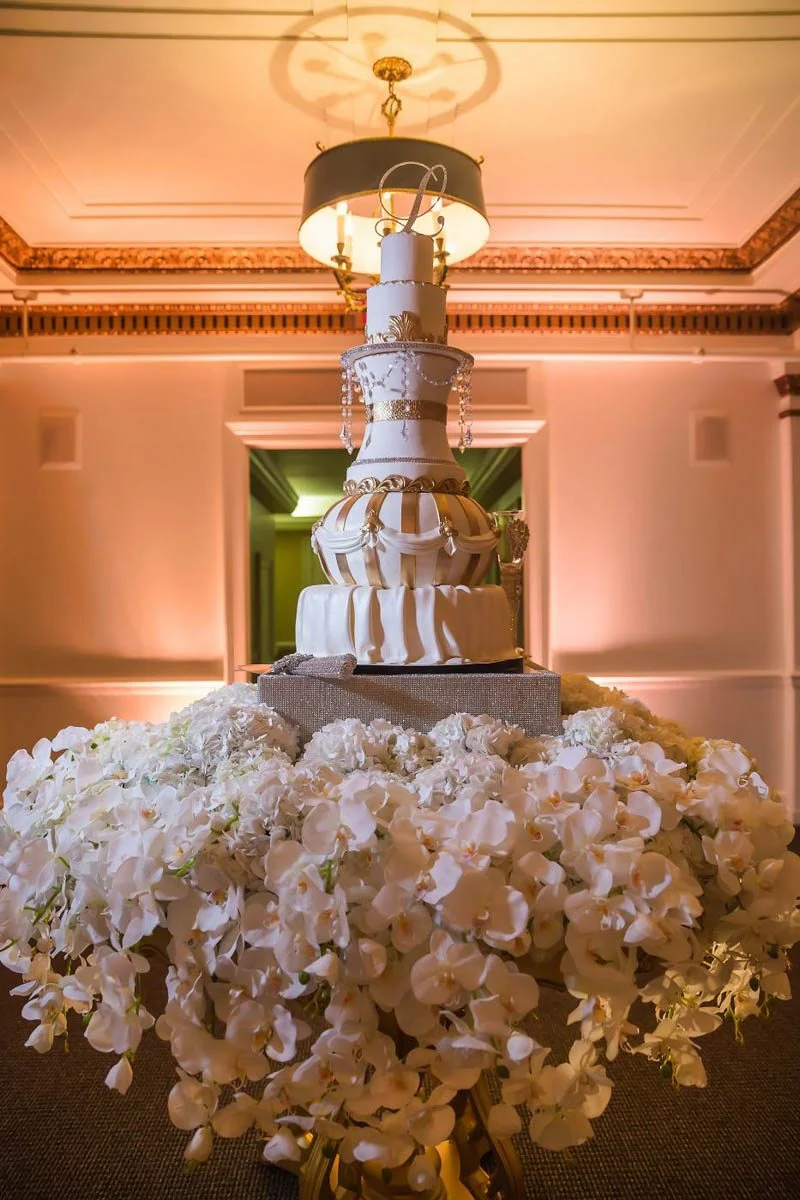 Gold-and-White-Tiered-Cake-with-Jewels-and-white-flowers-.jpg