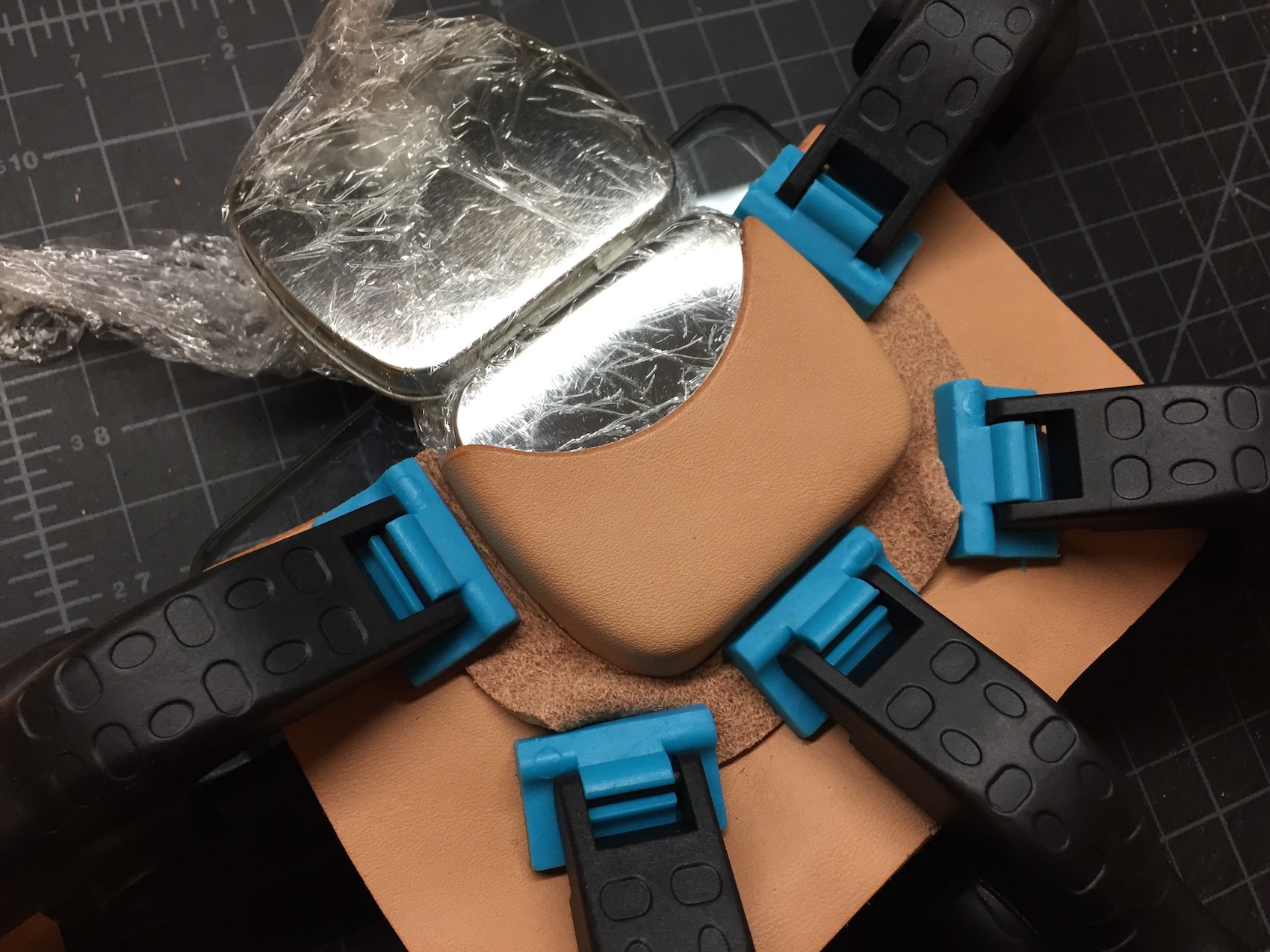 The third time, I placed one piece of leather cut to the curve of the tin under the clamps, grain side to grain side for the least amount of marking.
