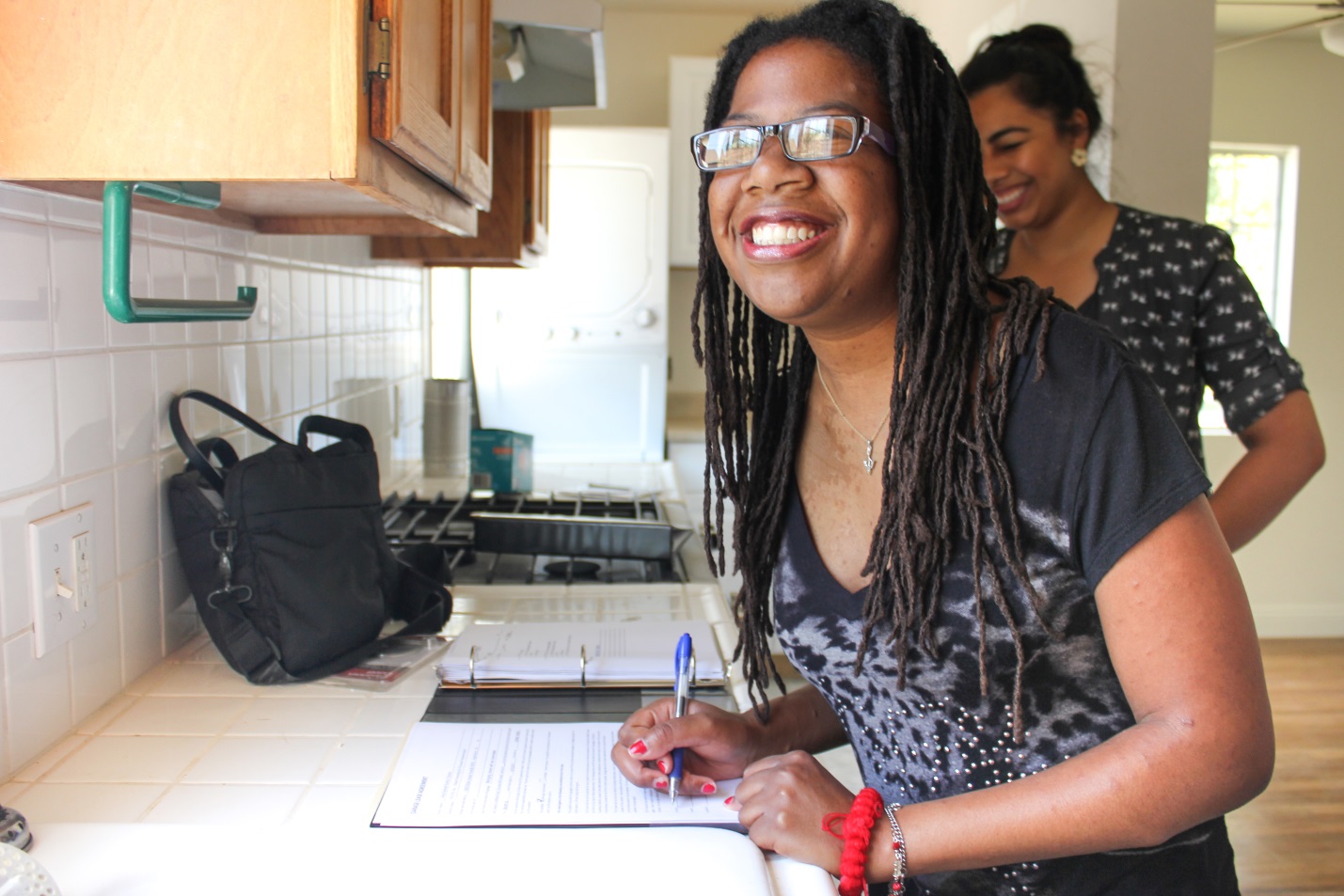 New resident, Asha, signs the lease at her first HOPE Independent Living home. Asha is the 71st person to receive housing as part of HOPE’s 80 by 18 goal.