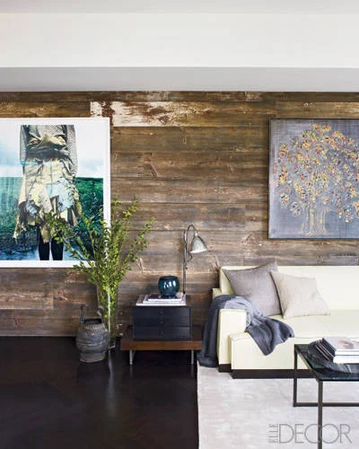 The living room walls are clad with reclaimed barn wood. Photograph by Jackie Nickerson. Painting by Carlos Vega.