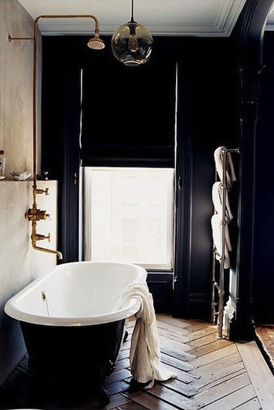 Love the herringbone timber floor, black stand alone bath tub, and copper feature pipe. Such a stunning bathroom full of texture and dark hues.