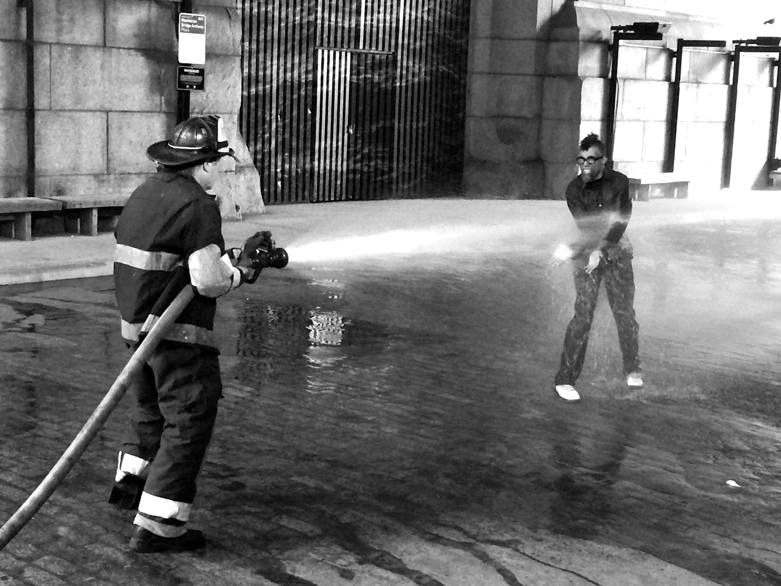 Dread Scott faces this fireman and the blast of water coming from the hose.