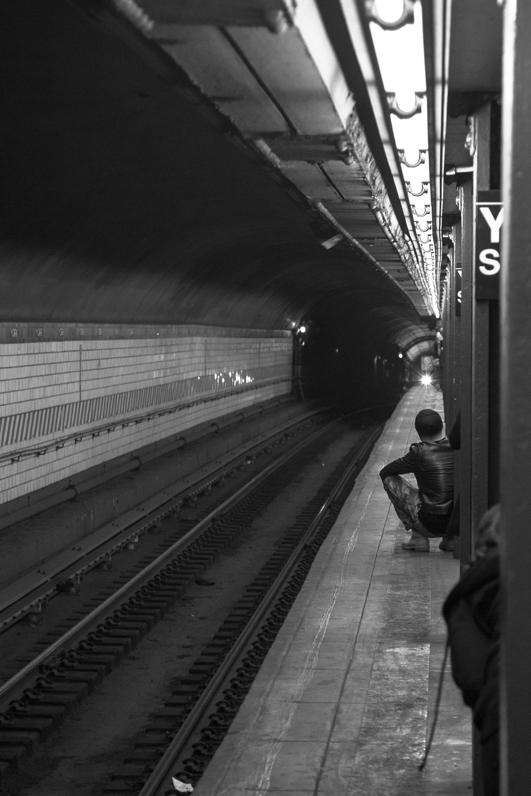 A young man waits for the F train at the York St. station, the last stop on the line before going into Manhattan from Brooklyn (or, the first stop in Brooklyn after leaving Manhattan)