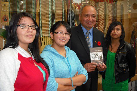 Reanne Elkins, Taylor Myers and Larissa Myers present Lieutenant Governor Stephen Pointe with a copy of the Squaw Hall Project DVD.