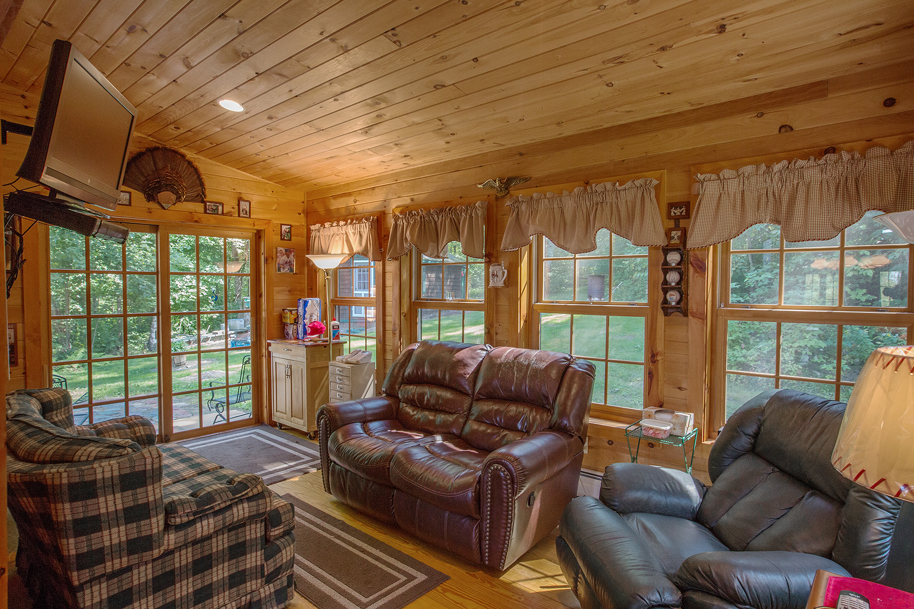  Additional living space. Smaller room that sits a tv, and a love seat.  Ample of windows in this room to view the outside driveway area. 