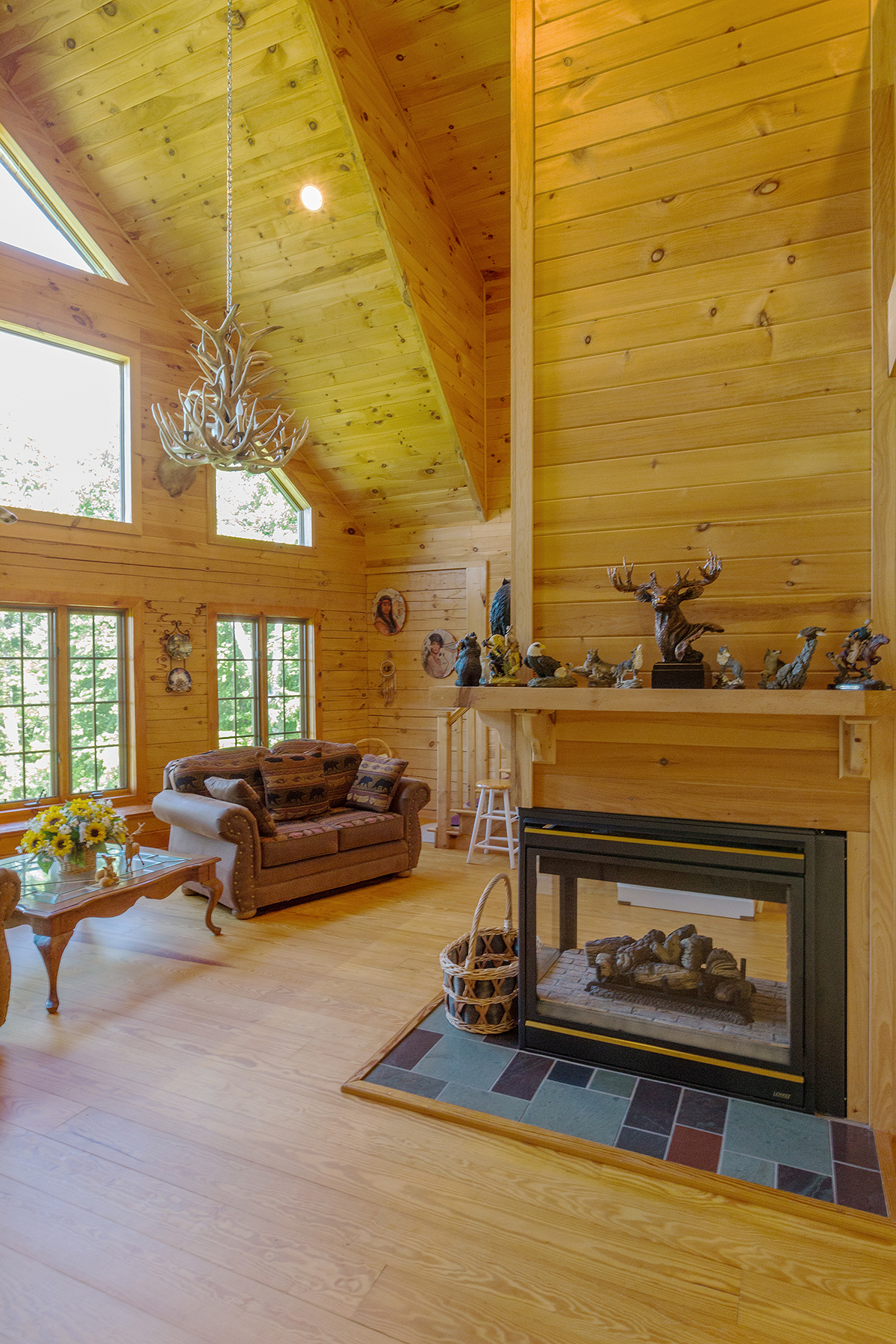  Glass window gas fire place in center of the room.  To the left is the wall of windows. Leather furniture in the living room. 