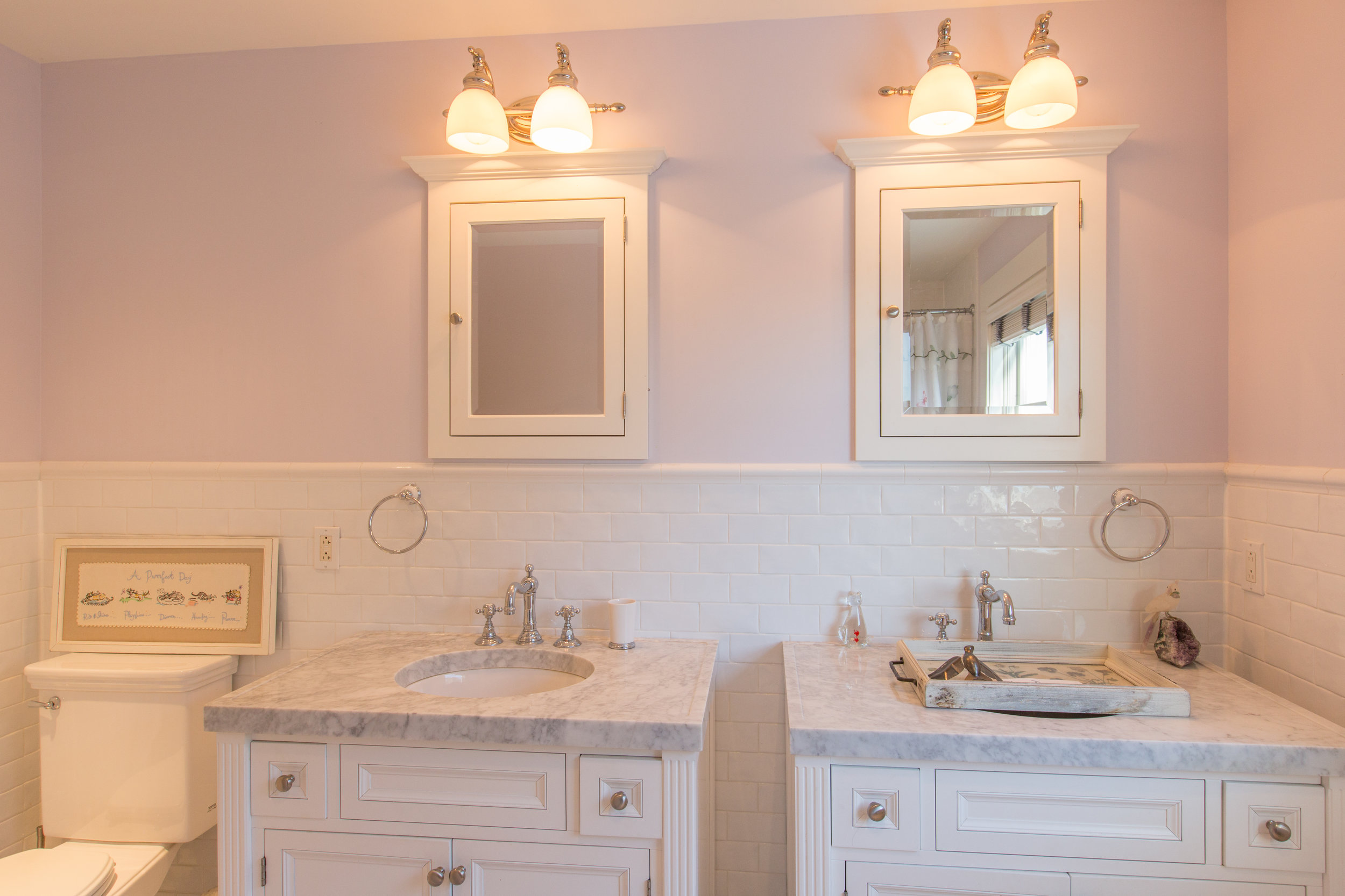 Bathroom with double vanity and double mirrors above. Toilet is to the left of the vanities.  