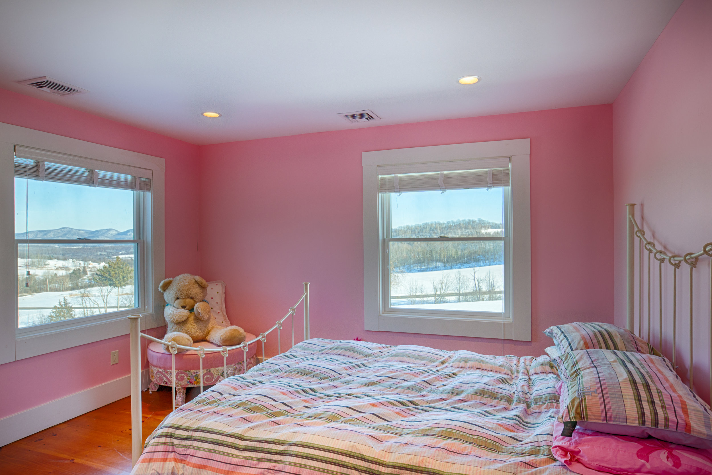  Bedroom with pink walls and white and pink striped comforter.  