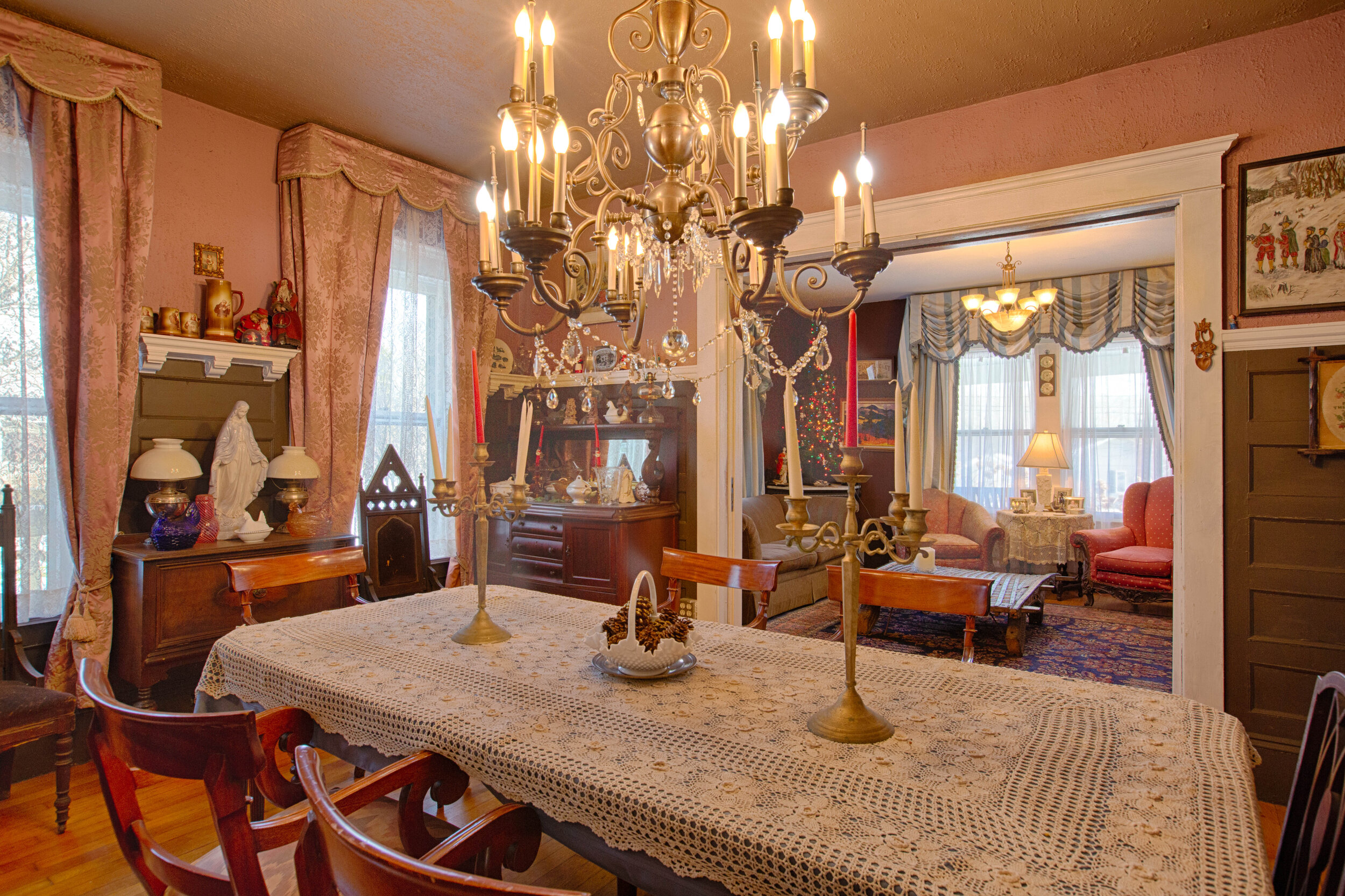  Formal Dining room that houses a very long rectangular table with a vintage candle style light above the table. 