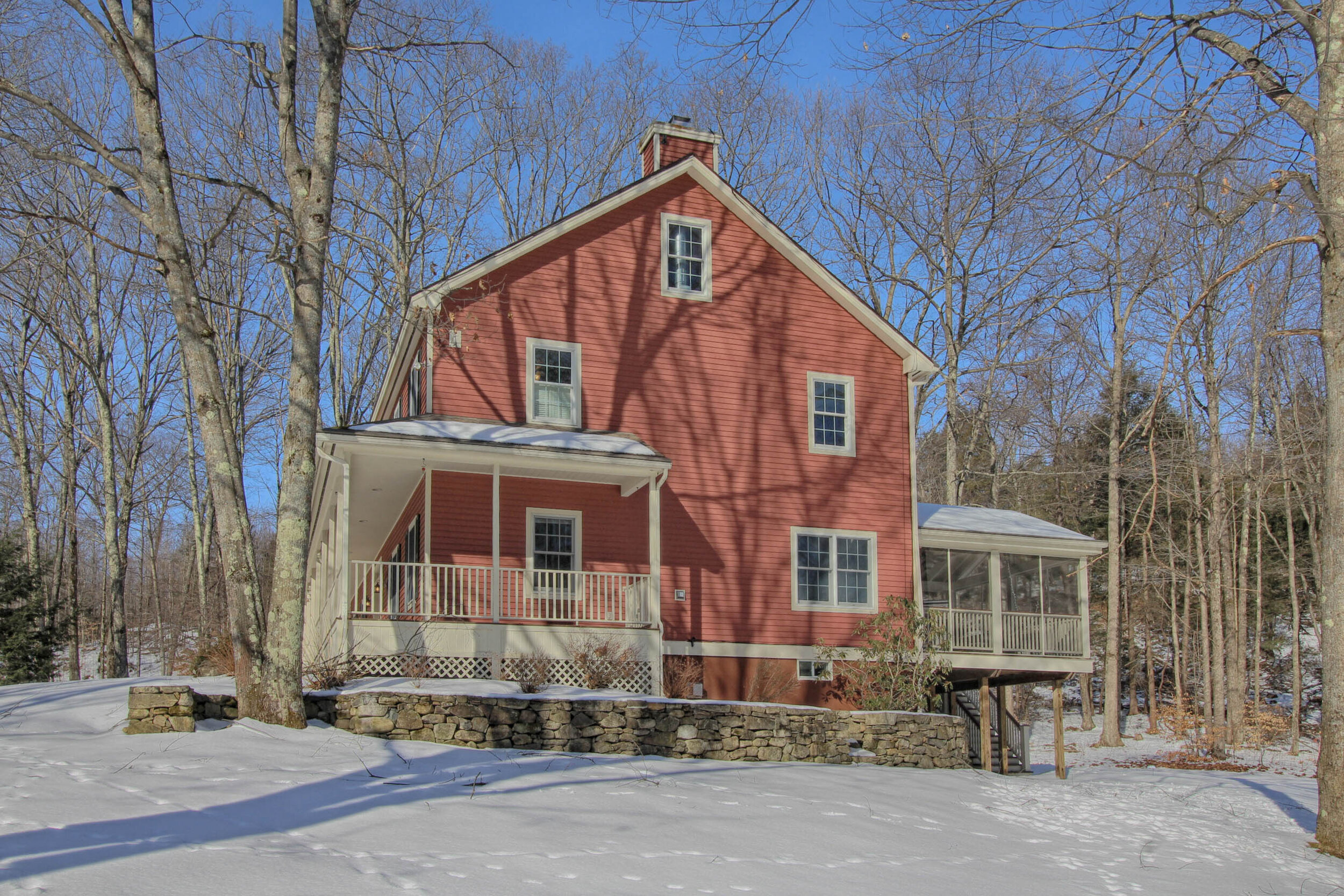  Outside side view of the home showing to the left the covered front porch and to the right the screened in porch. 