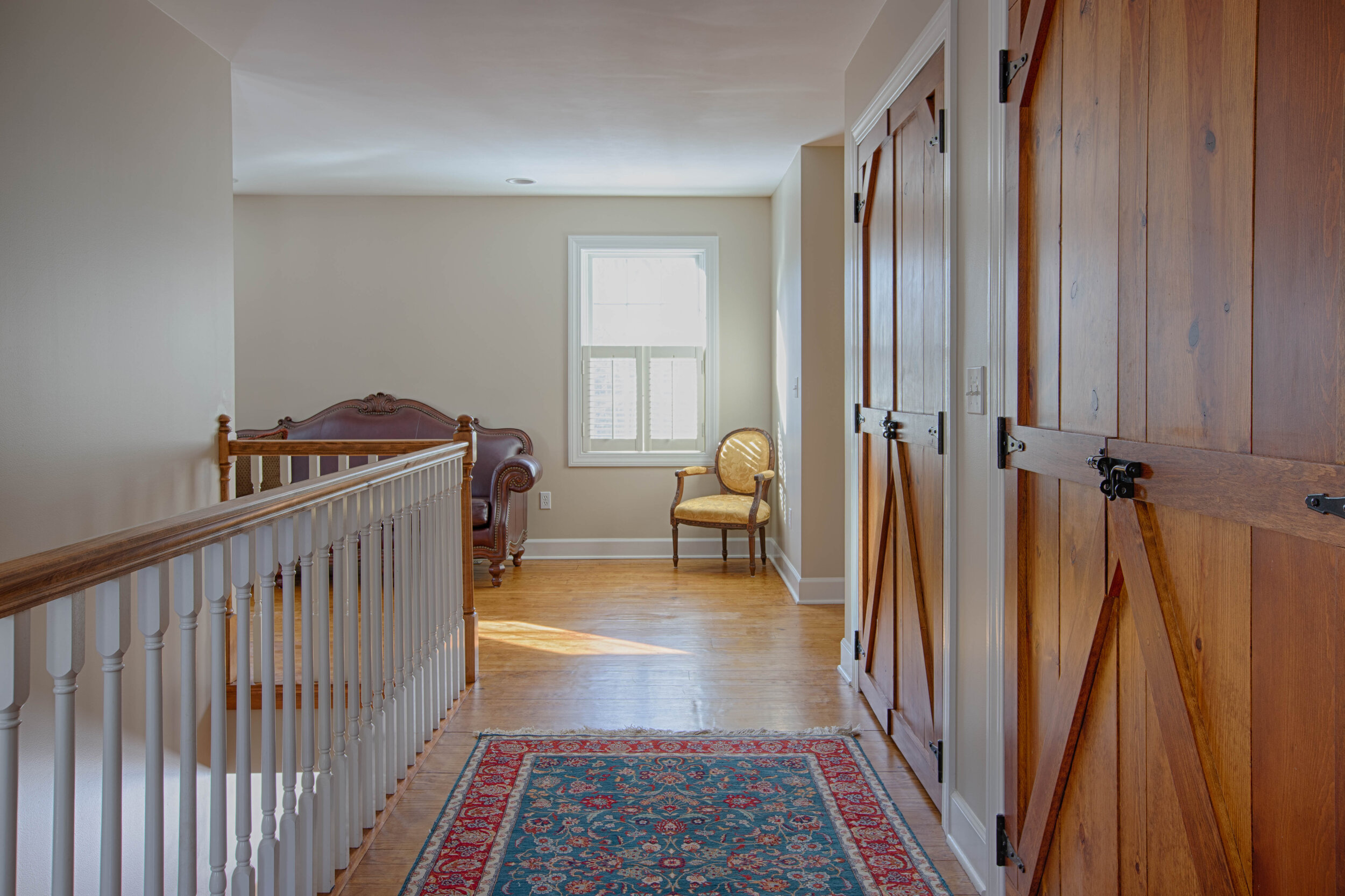  Upstairs hallway with balcony looking downstairs not he left side of the photo and wood, barn doors to the right. 