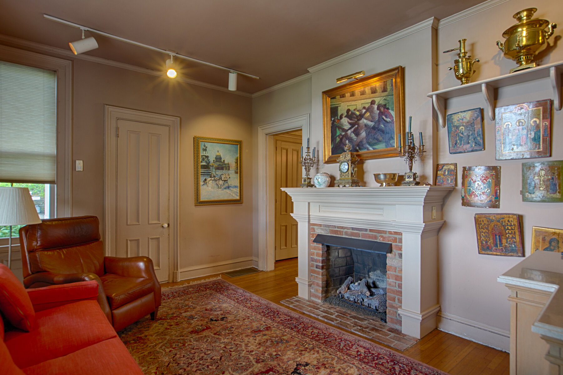  Another sitting room with furniture and recessed lighting. Working fireplace with a red brick face.  