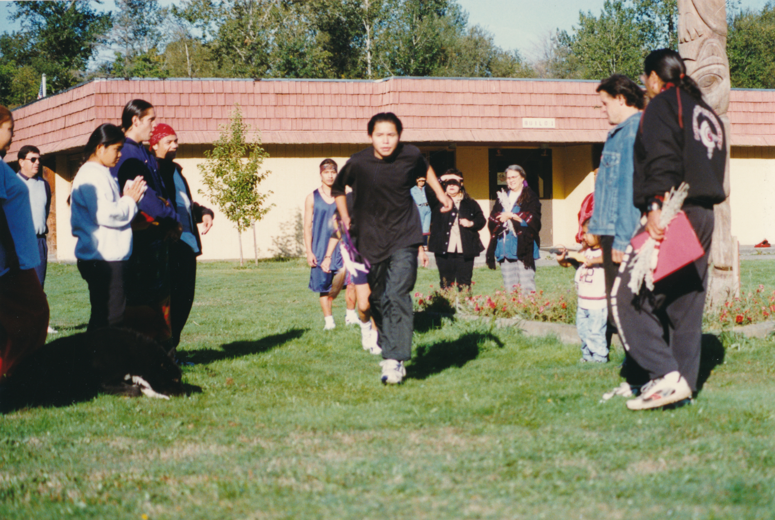 Anyone recognize the building in back? I would love for that community to have this photo. Dennis Banks (far right) being coach/ cheerleader