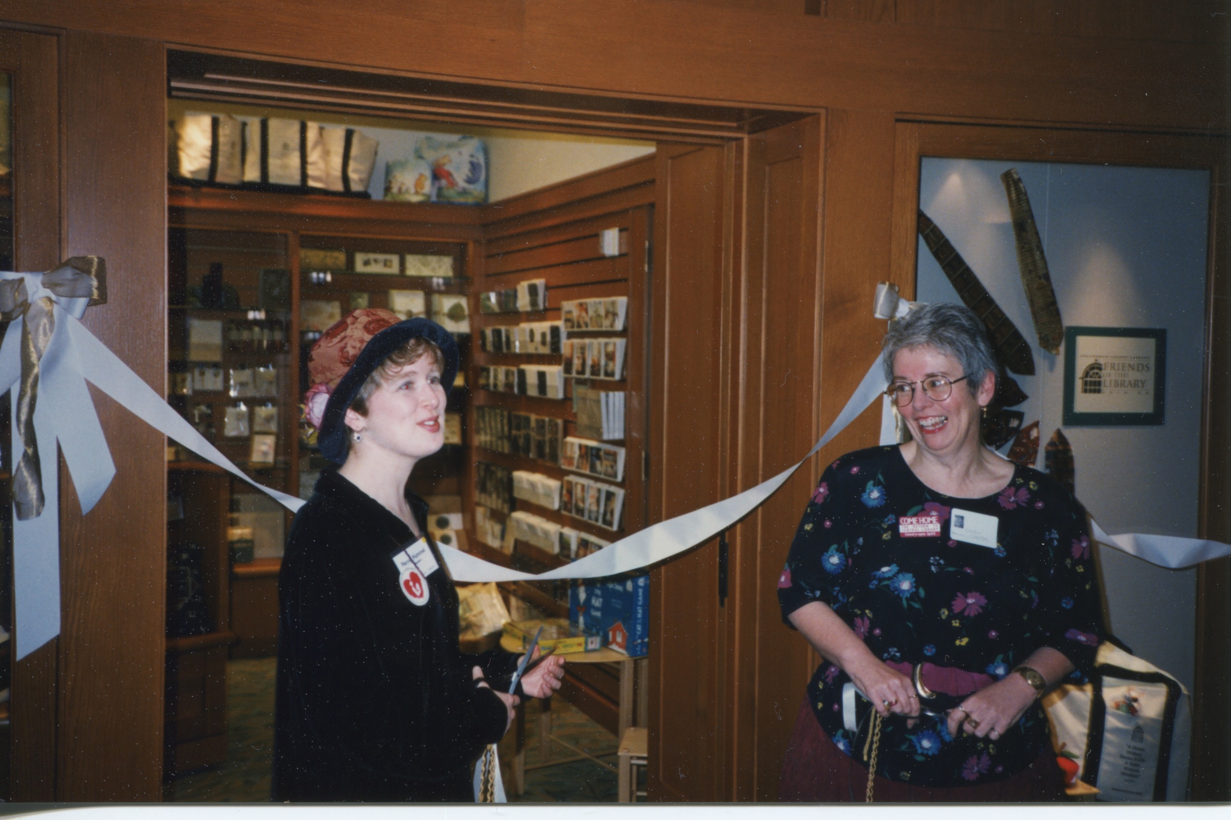 1997. The Friends of the Library President cuts the ribbon of the new Friends' Library Store at Central Library with director Ginnie Cooper. 