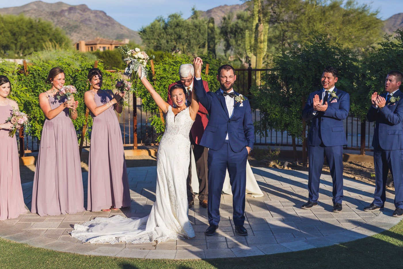 couple with arms in air celebrating after dc ranch wedding ceremony