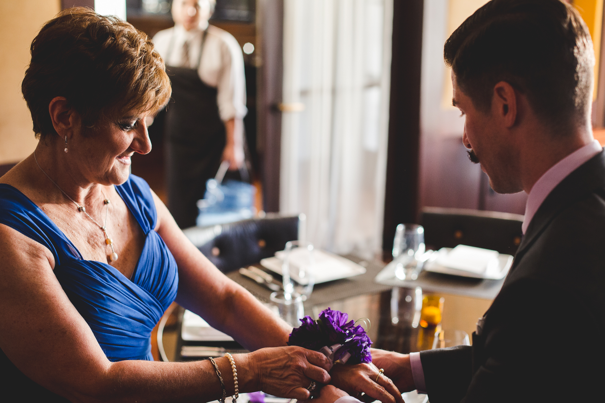 chad groom puts corsage onto mother of bride