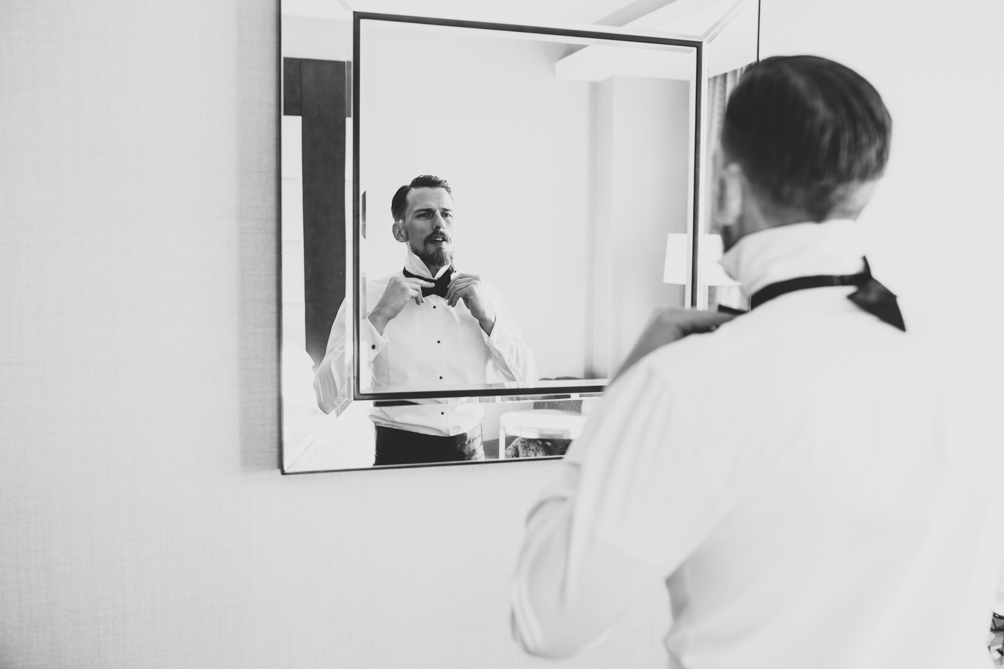 groom putting on bow tie black and white hj