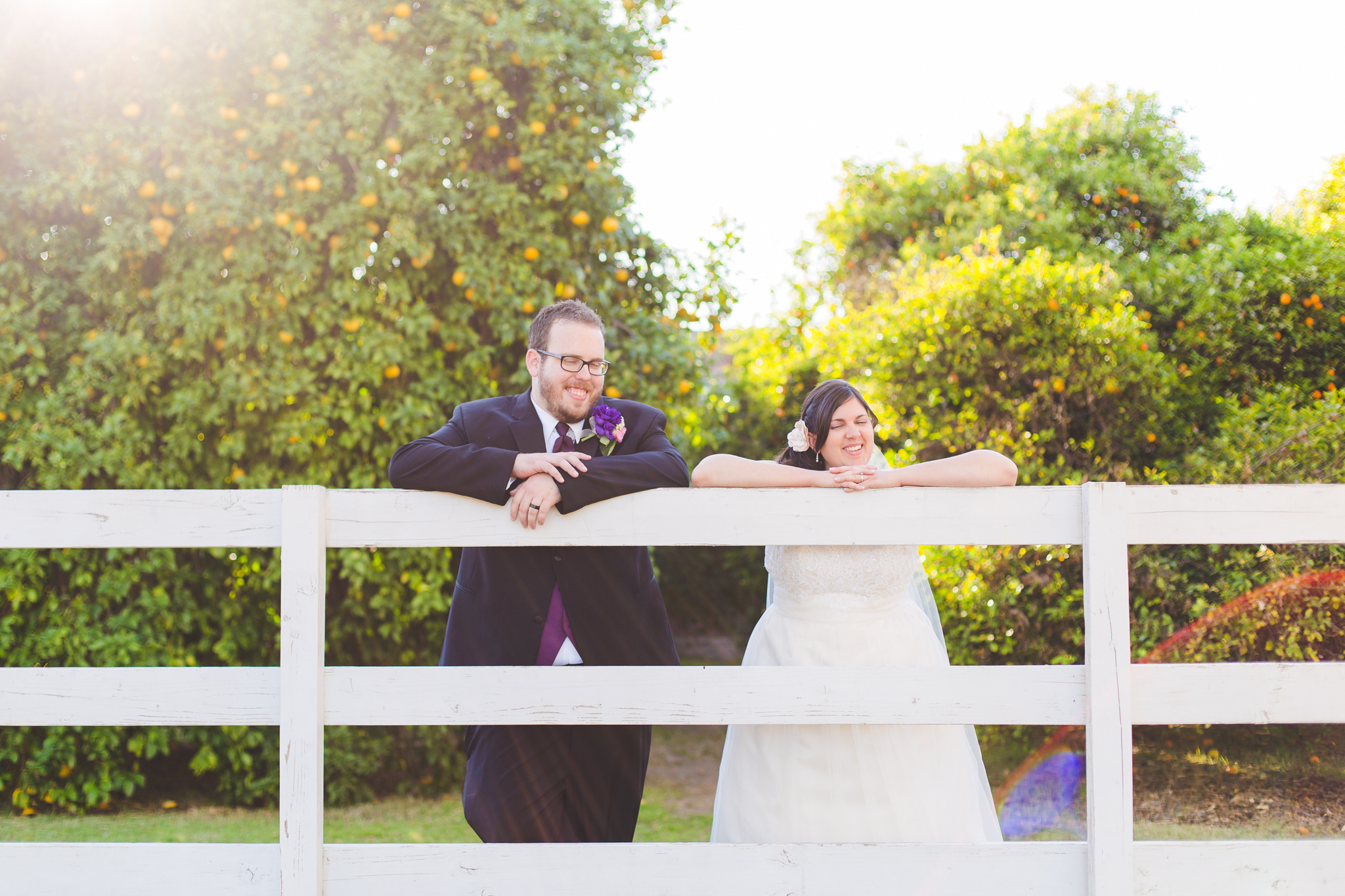 awesome lens flare with bride and groom on fence sd