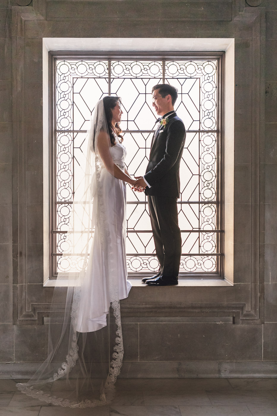 bride-and-groom-standing-in-window-san-francisco-city-hall