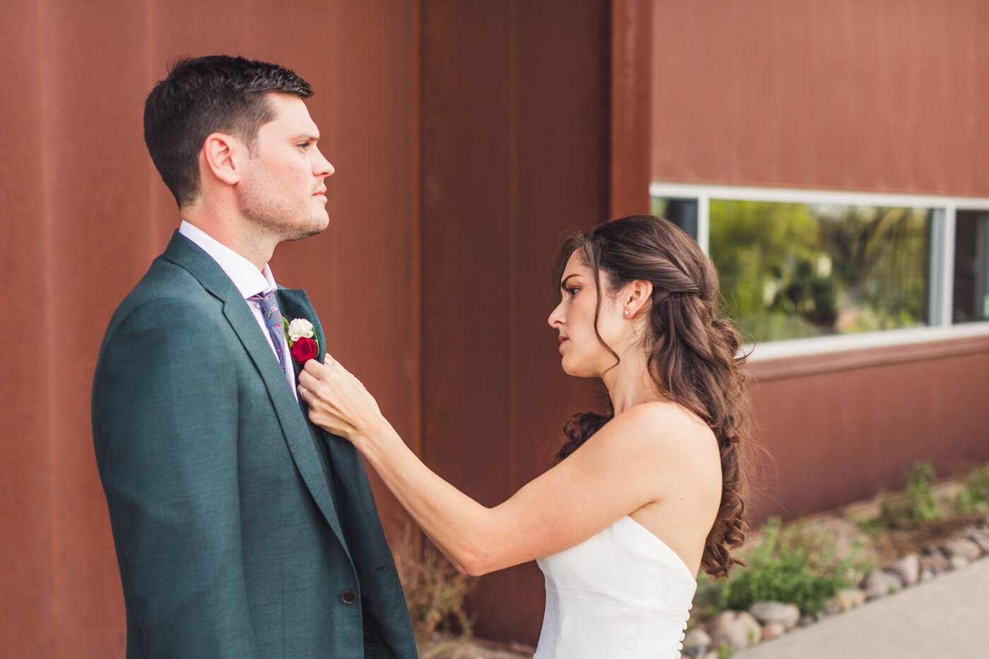 bride-putting-boutonniere-on-groom
