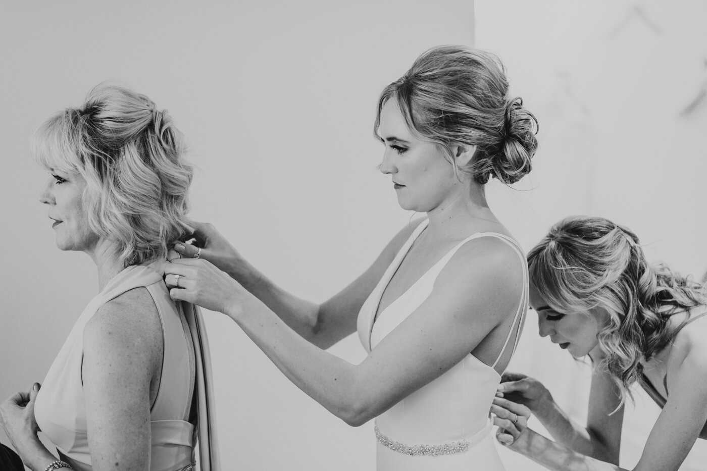 bride-mom-and-sister-all-helping-each-other-get-ready