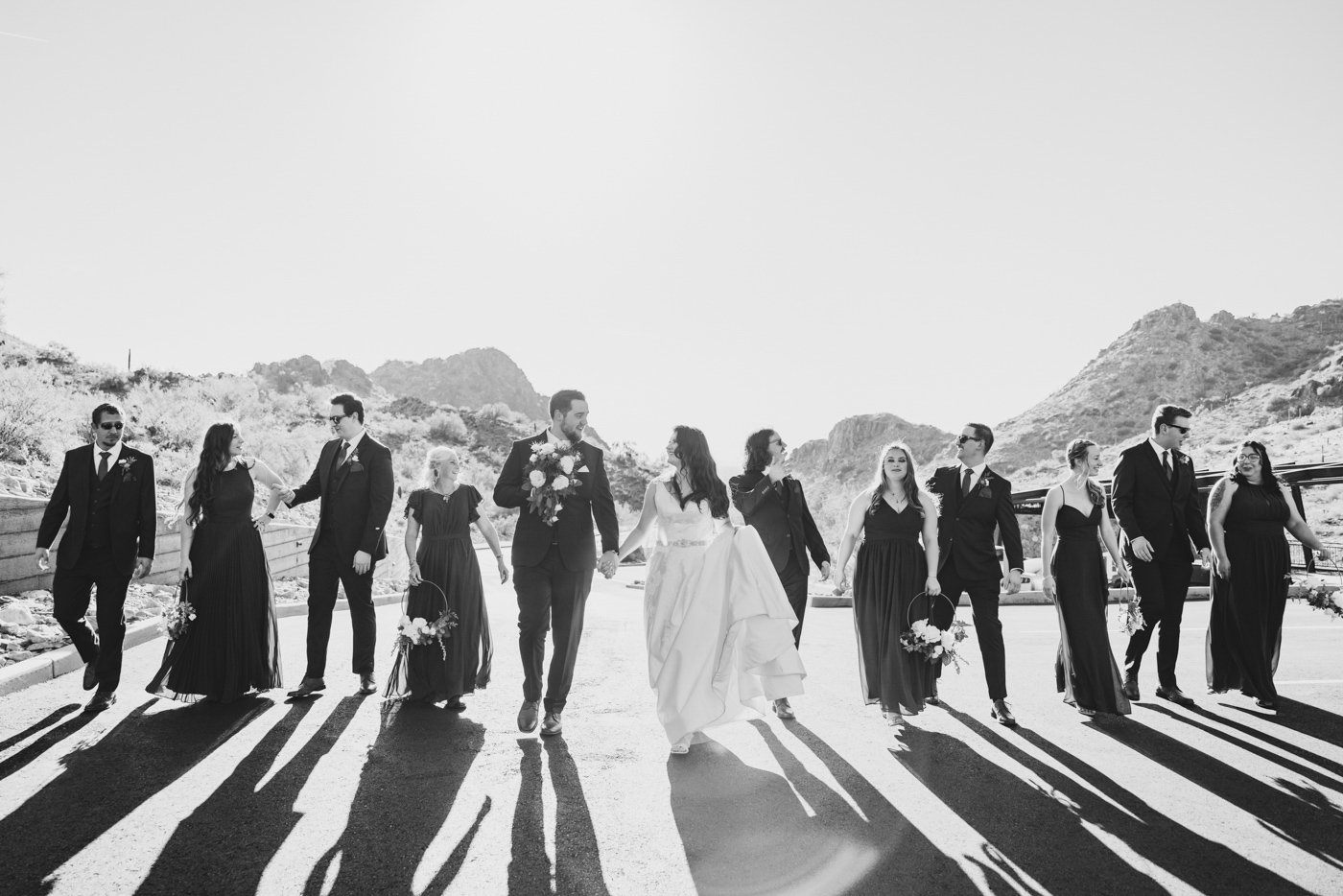 wedding party walking near mountains in black and white