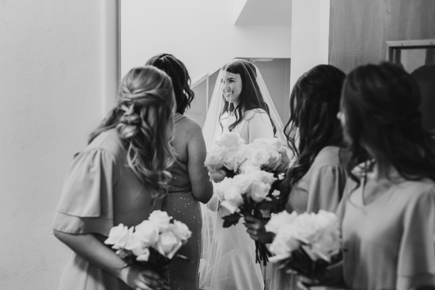 bride smiling at bridesmaids before wedding ceremony