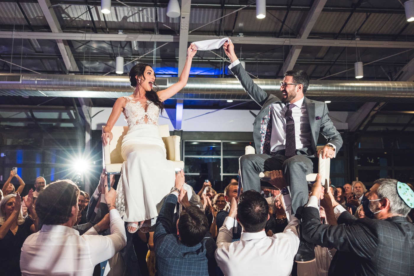 jewish bride and groom up on chairs during hora