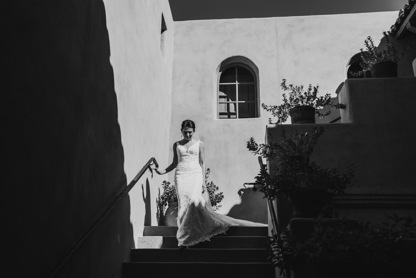 bride in the sun descending stairs in black and white