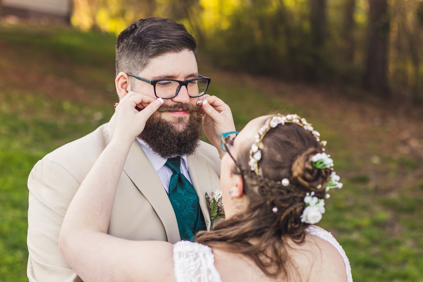 bride smooths out grooms handlebar moustache