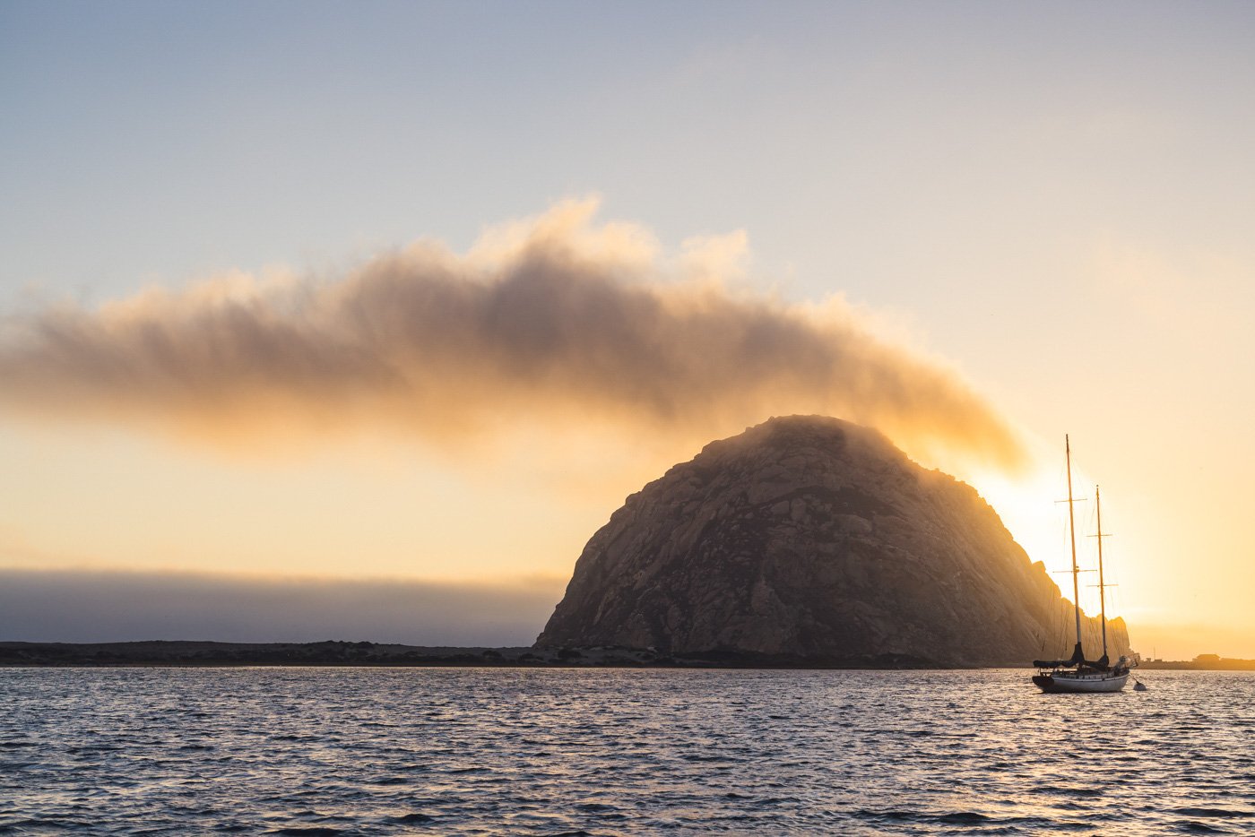 morro rock at sunset in california with ship in front
